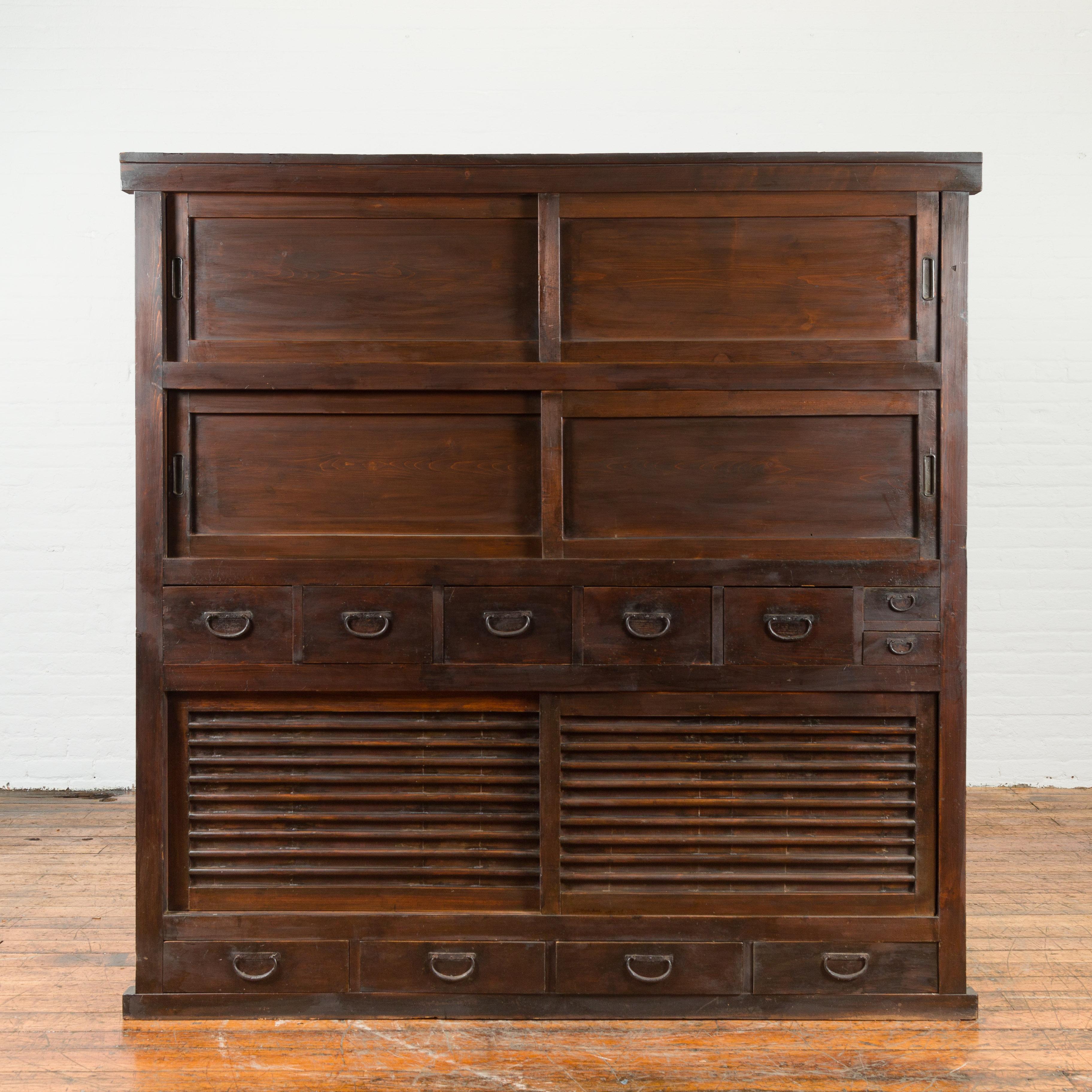 A Japanese Taisho period large single section wardrobe cabinet from the early 20th century, with three sets of sliding doors and iron hardware. Created in Japan during the Taisho period, this large cabinet features a perfectly organized façade made