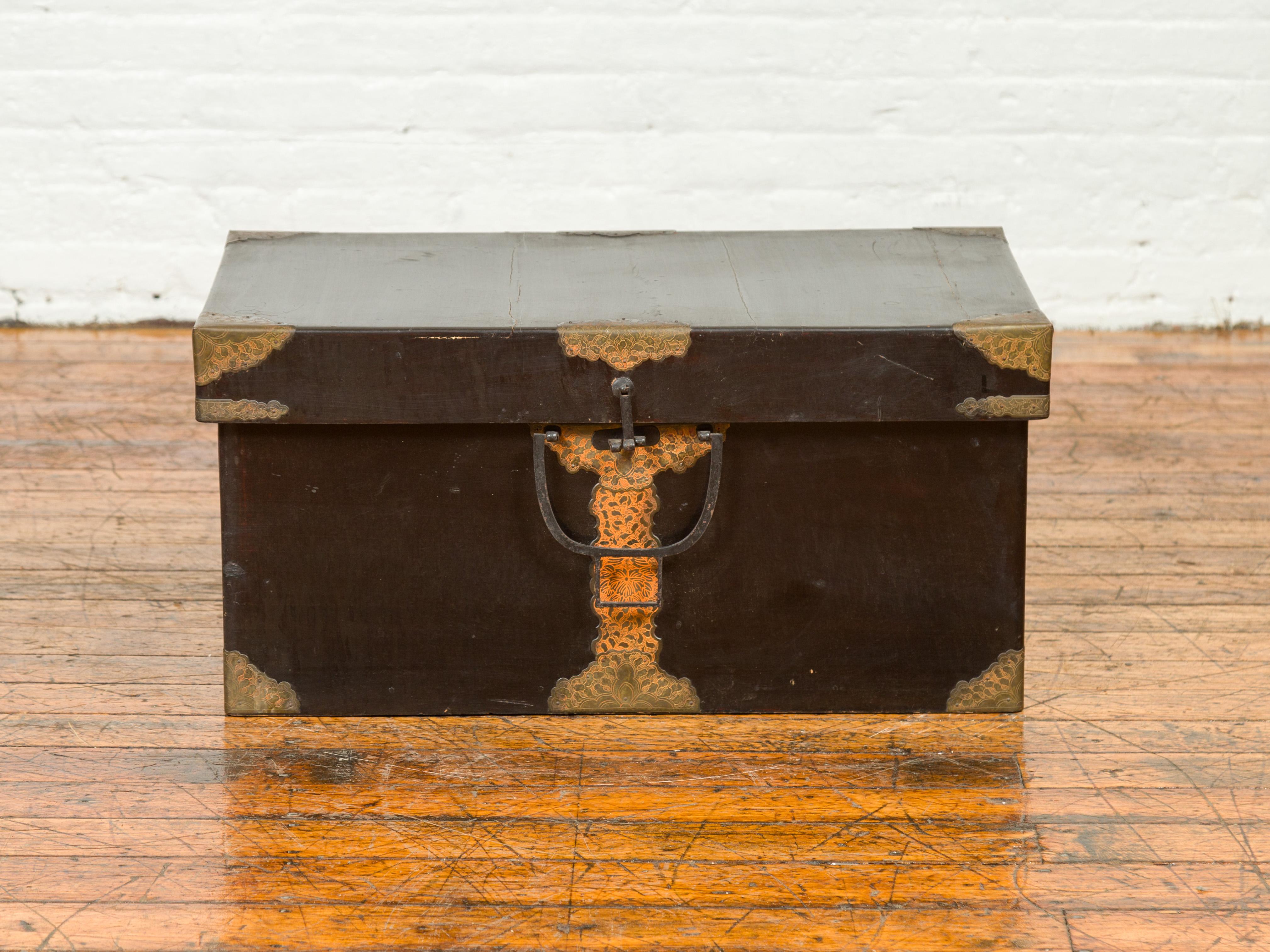 A Japanese Taisho period kiri wood lidded box from the early 20th century, with cut brass hardware. Crafted in Japan during the first quarter of the 20th century, this large decorative box is made of kiri wood, a fine grained hardwood, boasting a