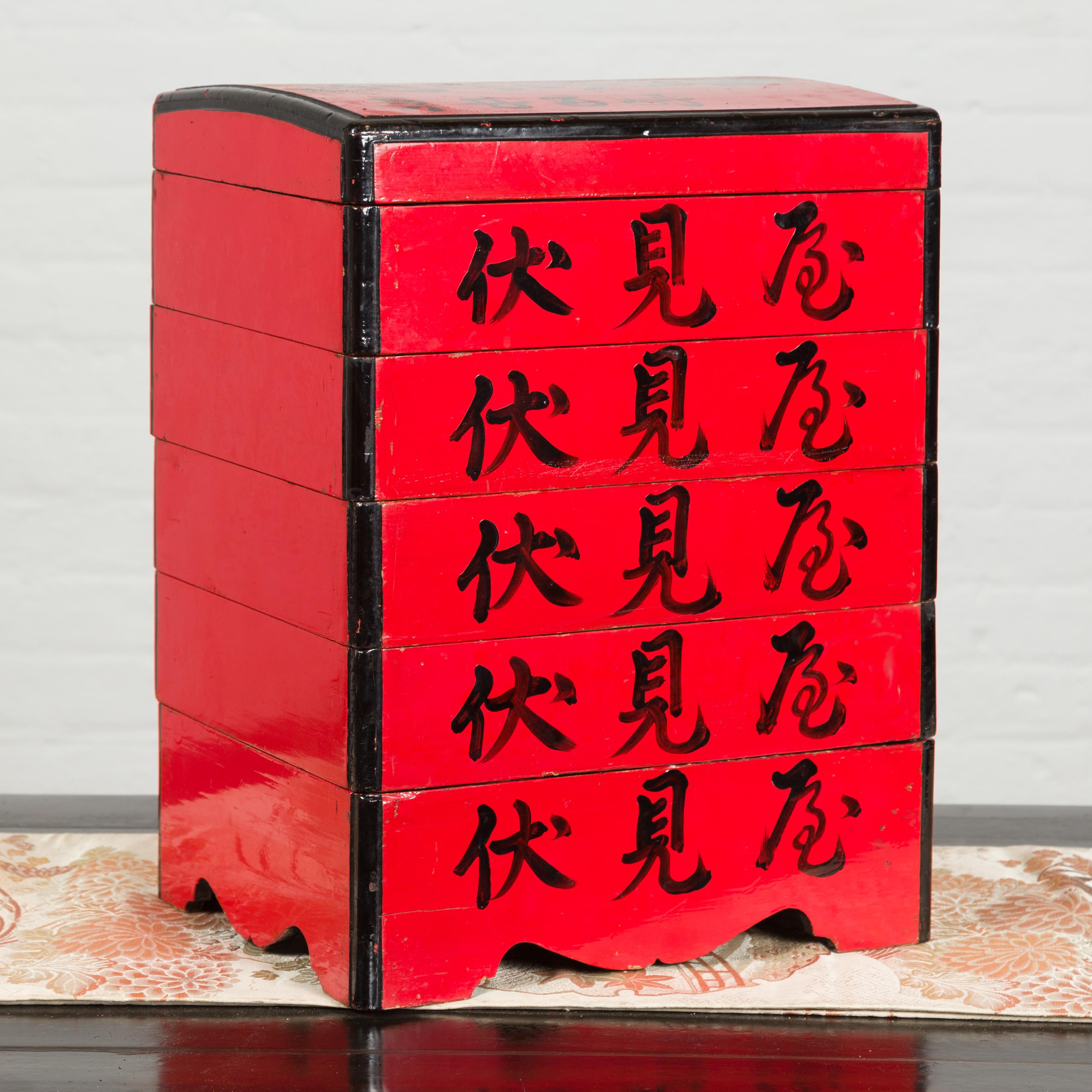 A Japanese Taisho period tiered food box from the early 20th century with red lacquer and calligraphy. Created in Japan during the early years of the 20th century, this red lacquered food box showcases an arching lid sitting above five individual