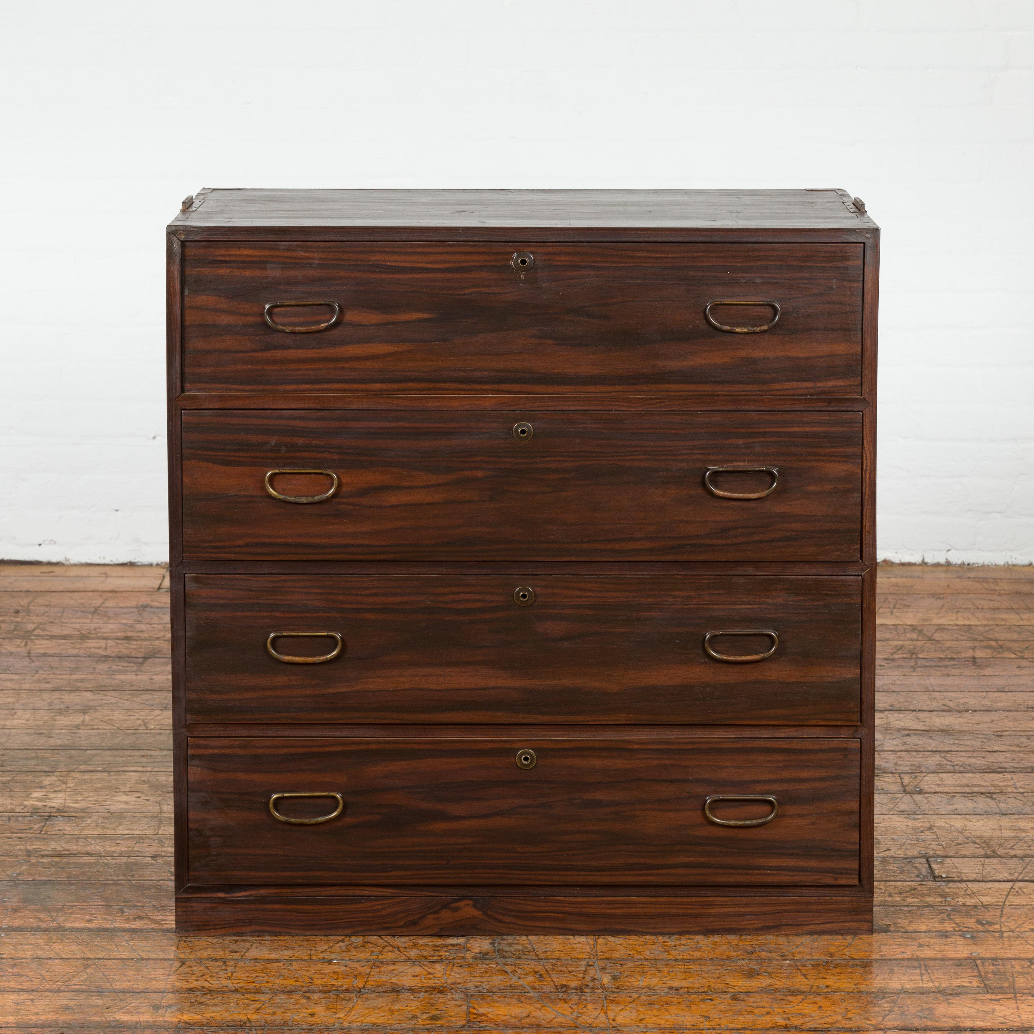 A Japanese Taisho period zebra wood tansu chest from the early 20th century with four drawers, brass hardware and pierced side handles. Elevate your home with the raw beauty of zebra wood, presented in this captivating Japanese Taisho period tansu