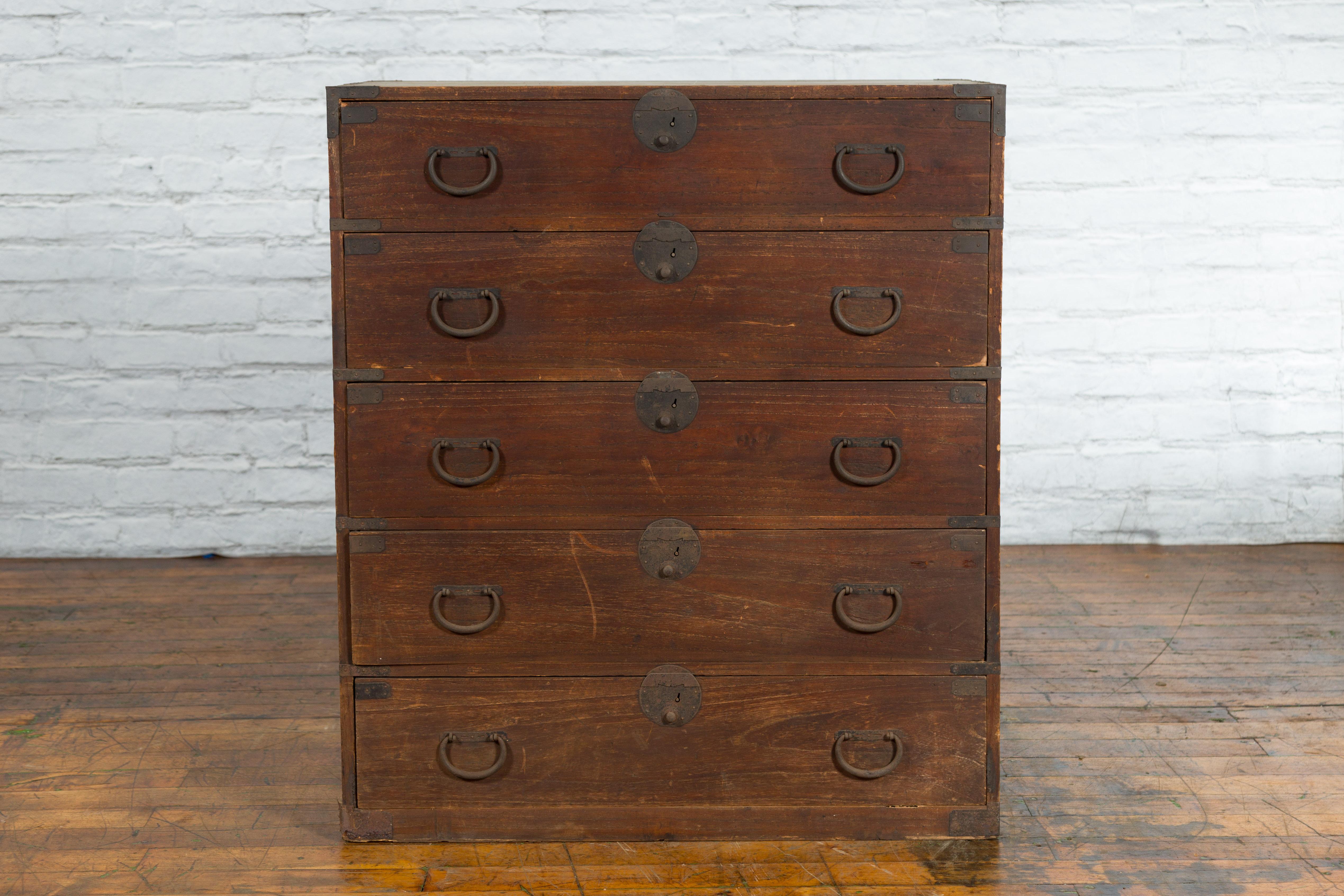 A Japanese Taisho period wooden tansu clothing chest from the early 20th century in Isho-dansu style, with five drawers and iron hardware. Created in Japan during the Taisho period in the early years of the 20th century, this wooden Isho-dansu