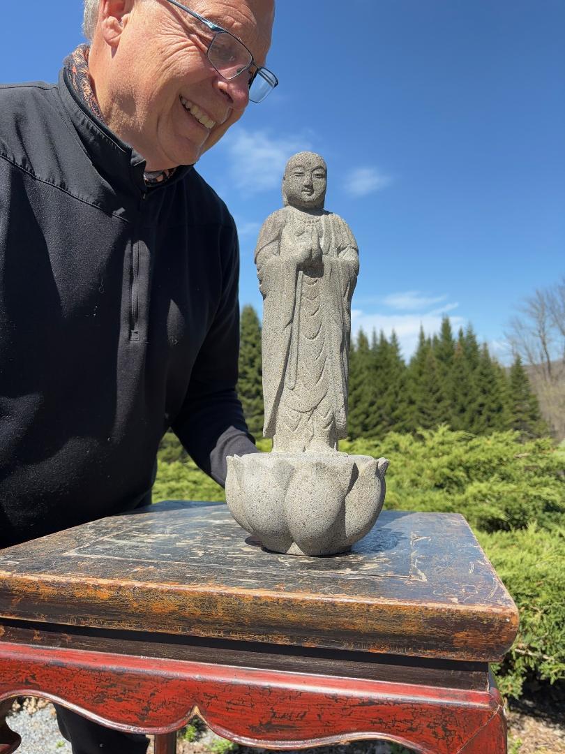 A slender tall granite stone Buddha/Jizo Guardian sculpture perched upon a lotus base

Good garden candidate

In Japan, Kṣitigarbha, known as Jizō, or respectfully as Ojizō-sama, is one of the most loved of all Japanese divinities. His statues are a