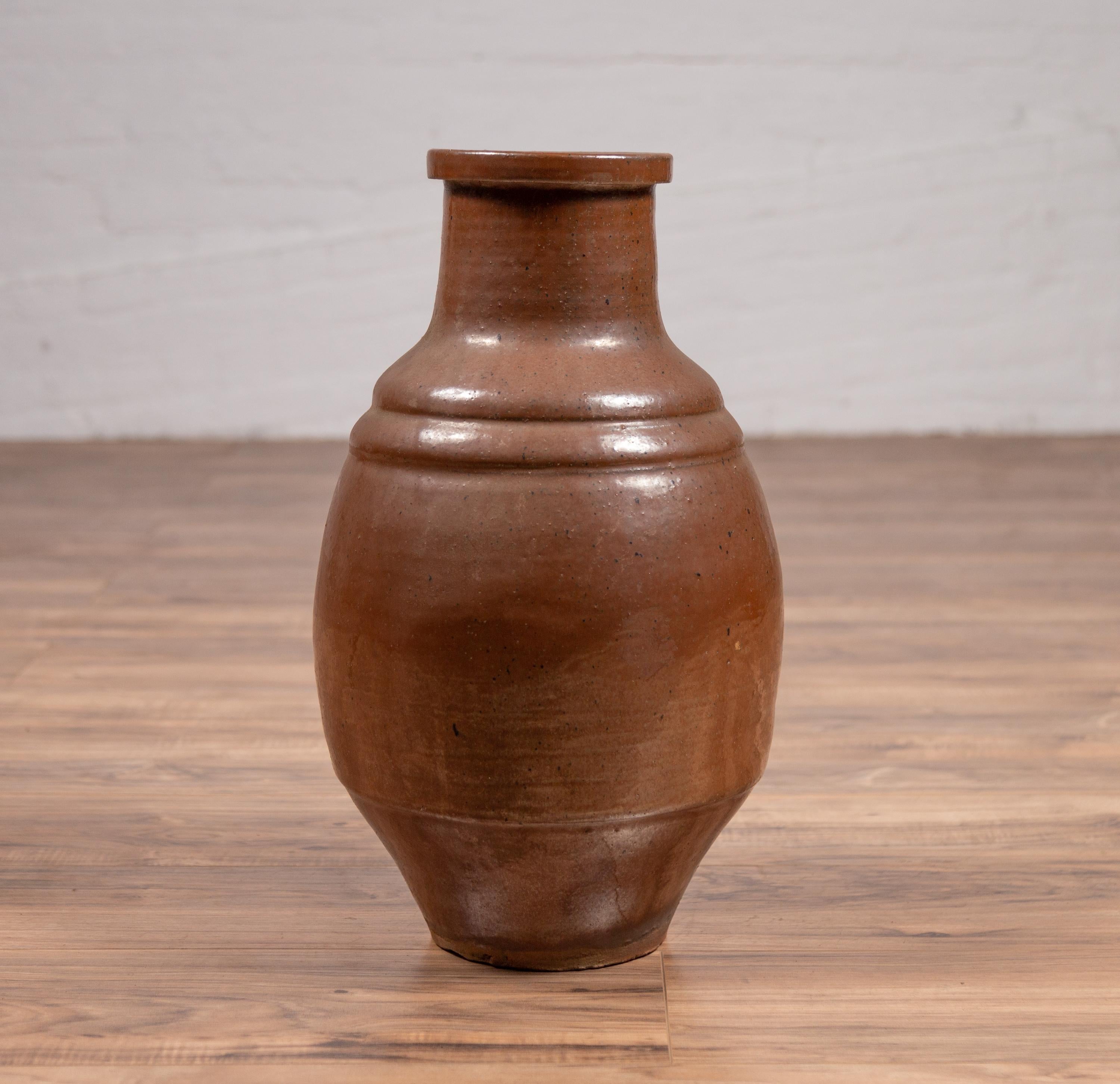 A Japanese Tamba Tachikui ware brown glazed water jug from the 19th century. Boasting a lovely monochrome brown color, this Japanese jug was produced in one of Japan’s six famous ancient kilns. Showcasing a circular body with narrow neck, ribbed