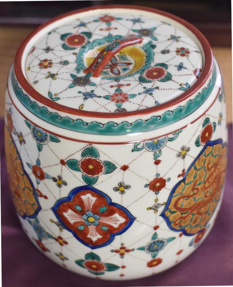 Japanese contemporary porcelain mizusashi water jar, hand-painted in green, red and gold featuring gilded panels of the mythicalChinese dragon, an amalgam of nine beasts. Believed to have power over rain, the dragon makes an oblique reference to the