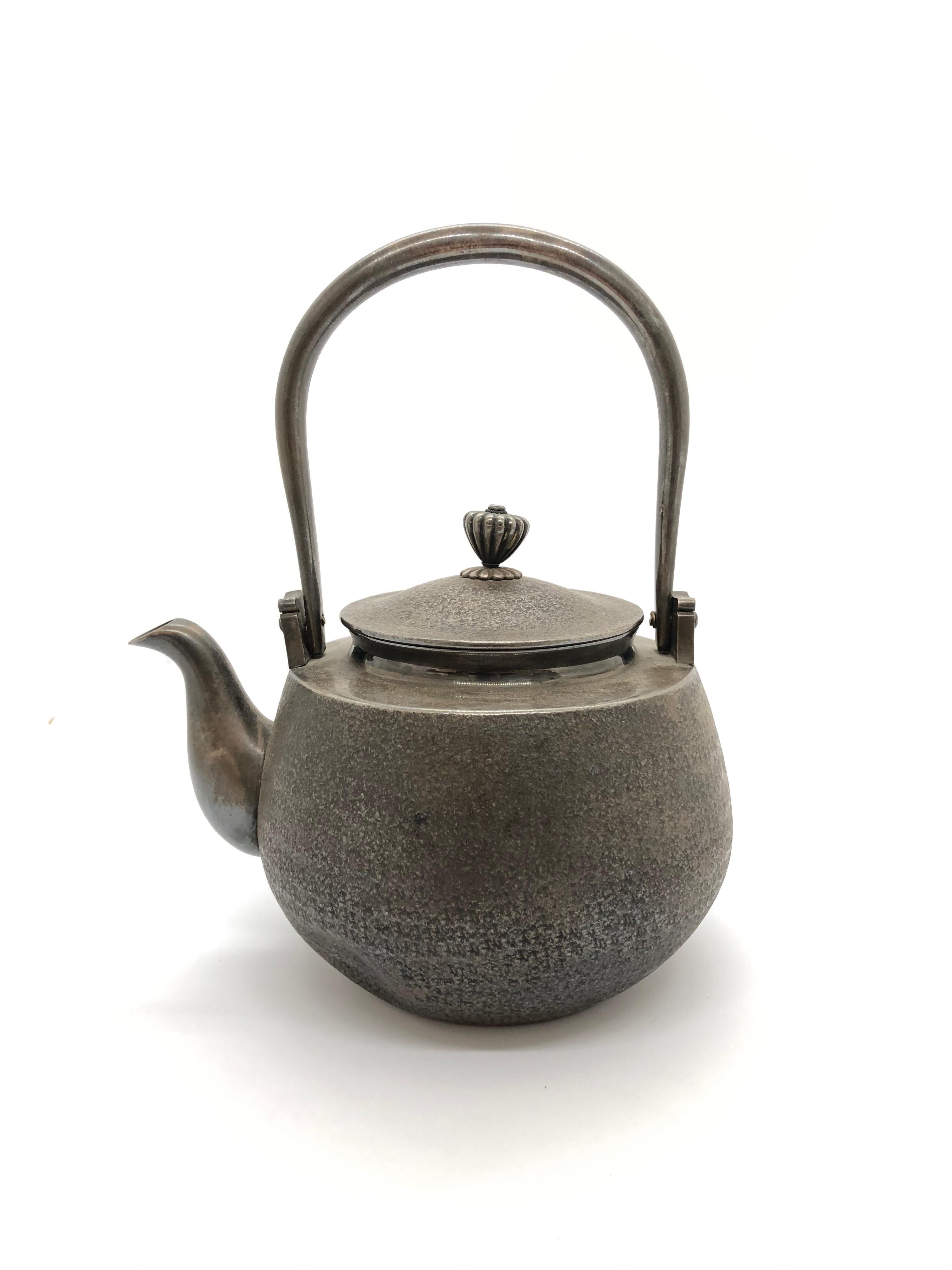 A silver teapot with a great design, signature and mark inside.