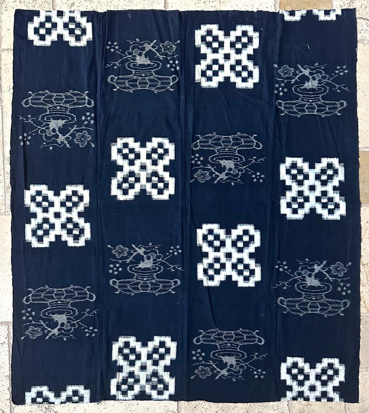 A Japanese woven cotton textile panel with white pattern on indigo background circa 1900-20s (end of Meiji to Tasho period). The panel was joined by four vertical stripes and was traditionally used to make the Futonji (futon coverlet). The weaving