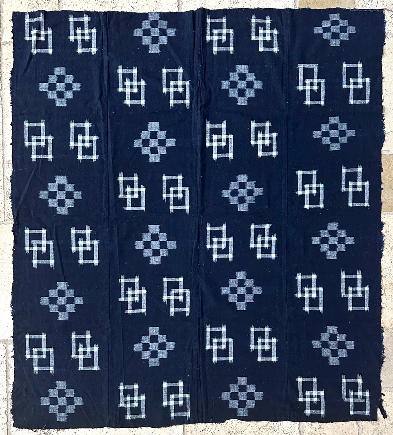 A Japanese woven cotton textile panel with white pattern on indigo background circa 1900-20s (end of Meiji to Tasho period). The panel was joined by four vertical stripes and was traditionally used to make the Futonji (futon coverlet). The weaving