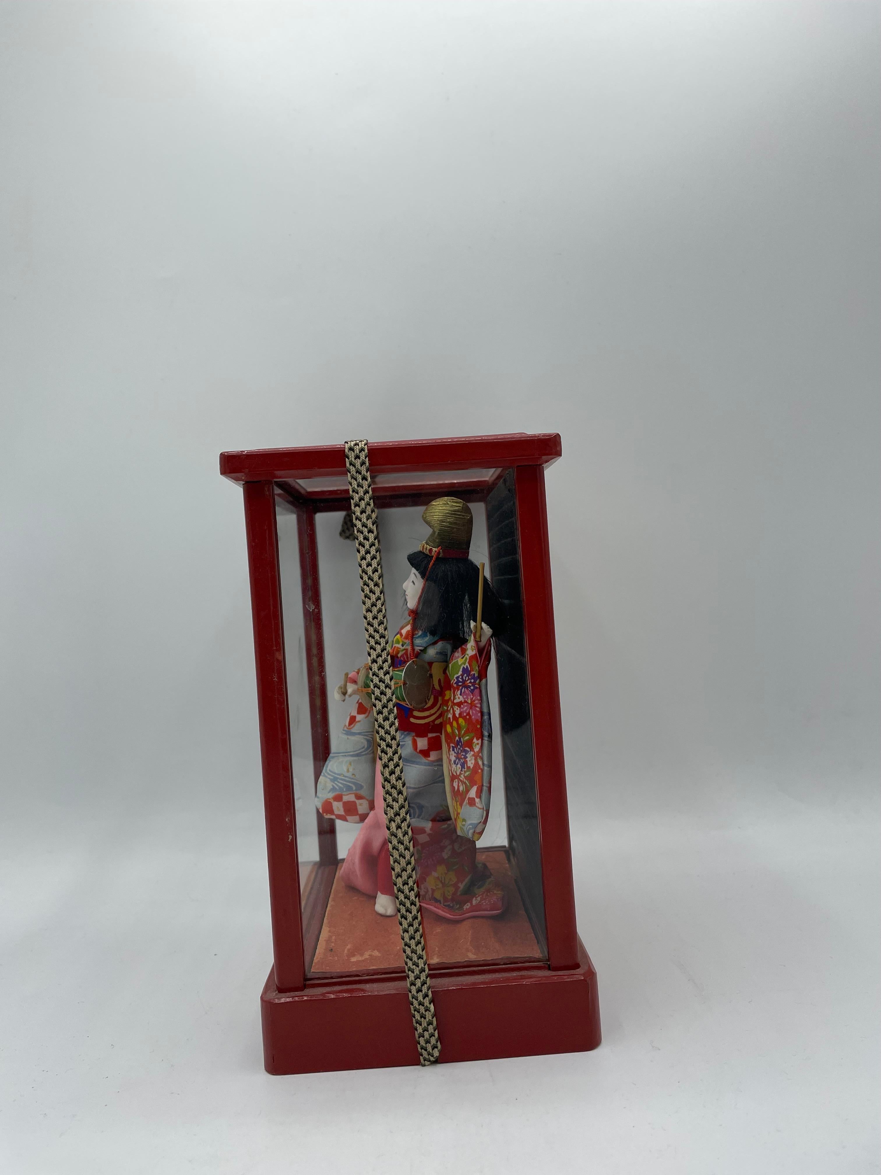 This is a Japanese Traditional doll which was made in 1970 in Showa era.
This doll is in a box which is made with wood and glass.
This doll is made with porcelain and she is wearing a kimono which is made with silk.

Dimensions:
H20 x 14.5 x 10.5 cm
