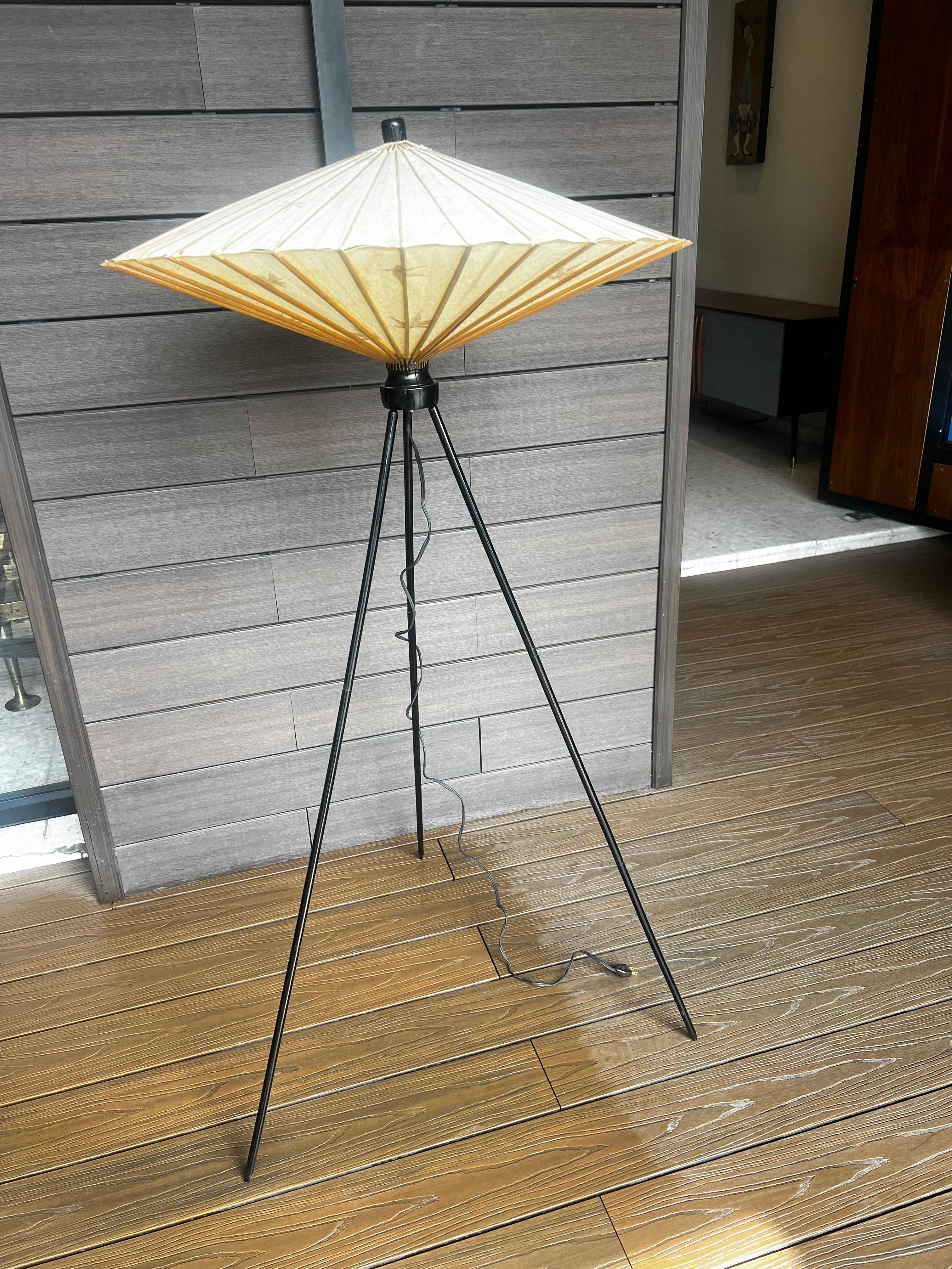 Kasa Dreibein-Stehleuchte, hergestellt in Japan in den 60er Jahren. Bestehend aus drei spitz zulaufenden Beinen aus schwarz lackiertem Holz und einem Lampenschirm aus Japanpapier mit einer typischen Form. Kleine Kette zum Ziehen unter der Steckdose,