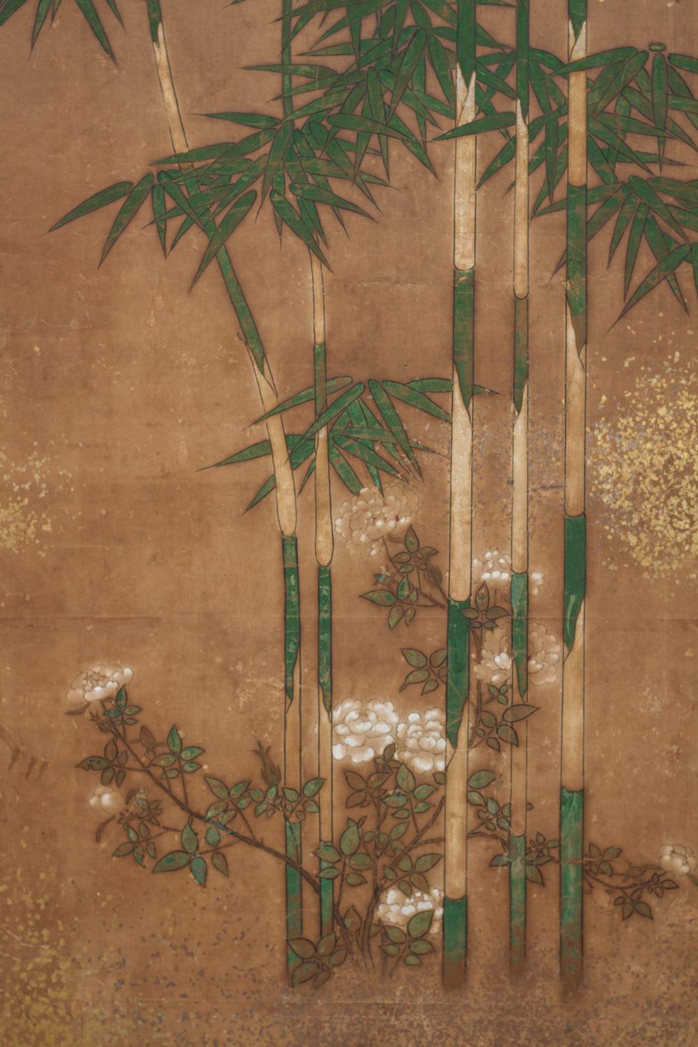 Kano School painting of a bamboo grove with blooming flowers and gold dust mists. Painted in mineral pigments on mulberry paper with gold dust and a silk brocade border.