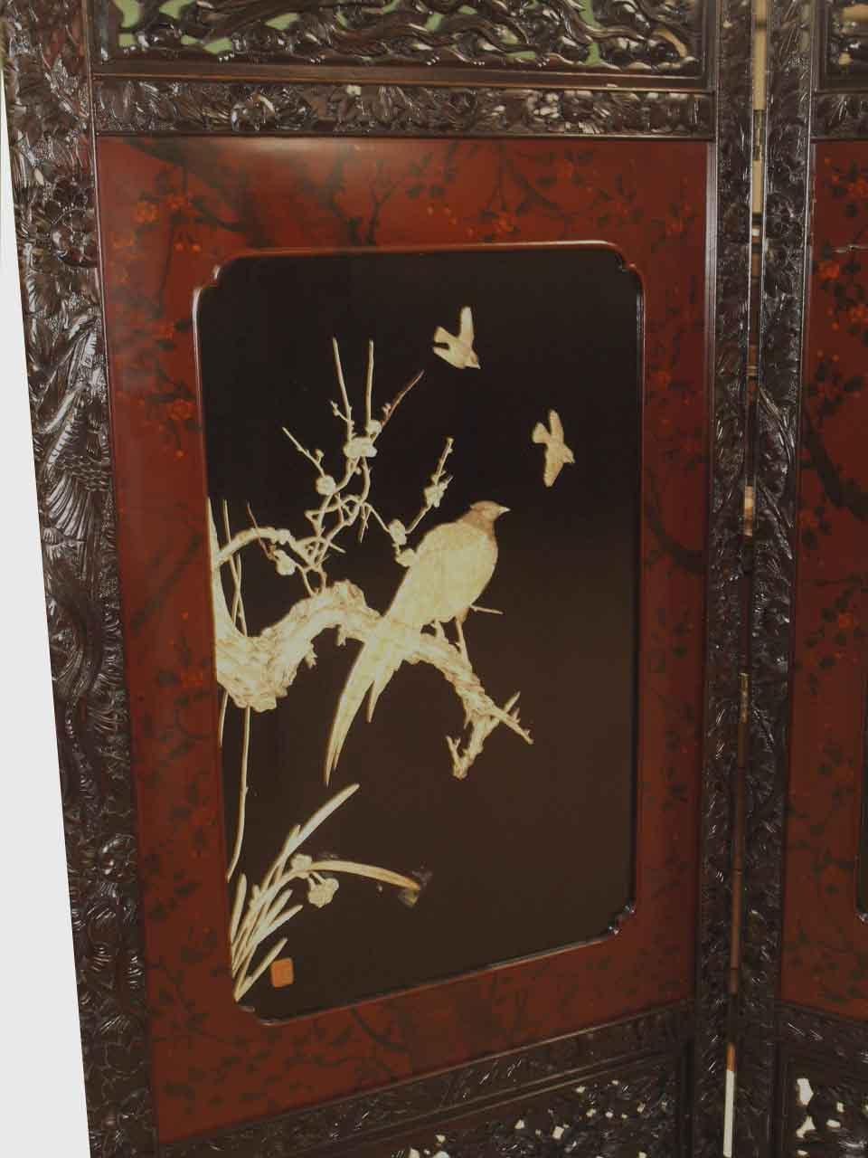 Japanese two fold carved lacquer screen, the top portion of each with reticulated carved bird and foliate work; the main body of each panel has a red lacquer border with painted flowers and foliate decoration encasing a black lacquer panel with