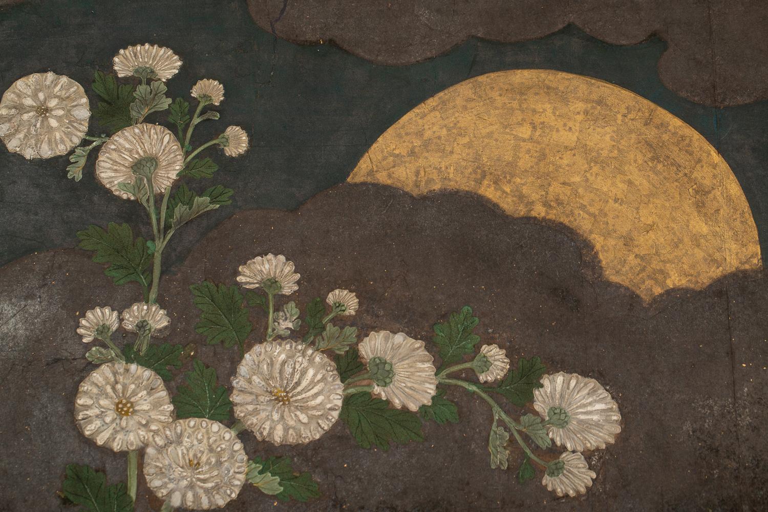 Rimpa style painting of raised chrysanthemums over raised baled twigs and branch fence. Gold and oxidized silver with mineral pigments and gofun on mulberry paper.