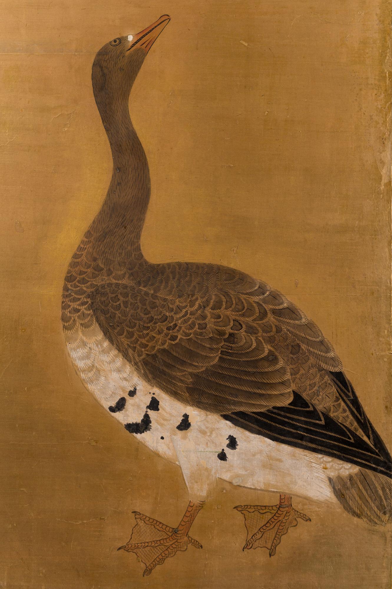 Japanese two panel screen: Geese on Gold, Edo period (circa 1800) painting of a pair of geese with wonderfully detailed feathers on a soft gold ground. Painted in mineral pigments on paper with a silver leaf border, black lacquer frame, and very