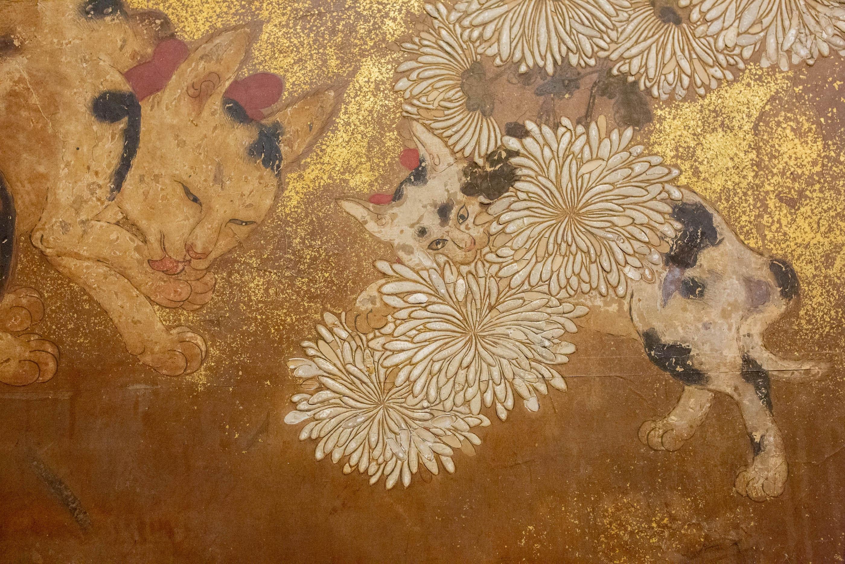 Delicate painting of garden chrysanthemums with a fine gold mist. A cat grooms herself while a kitten plays with a chrysanthemum. Mineral pigments, go fun, and gold dust on mulberry paper with silk brocade border. Painting in good condition with