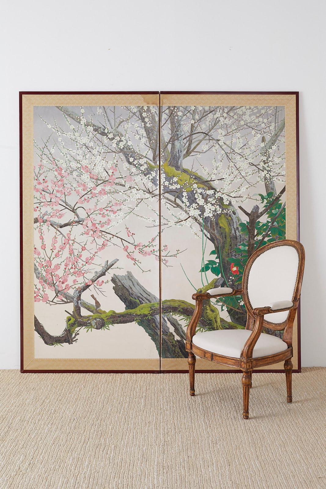 Captivating Japanese two-panel screen depicting early spring flora Prunus blossoms and Camellia on ancient trees. Grand scale screen with a unique modern style that has photorealism qualities that draw you into the colorful scene. Painted in the
