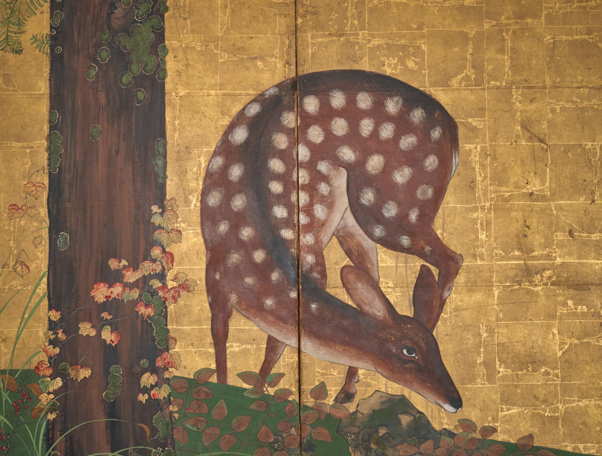 Hirsche auf Futtersuche unter einem Hinoki-Baum in herbstlicher Umgebung. Mineralische Pigmente auf schwerem Blattgold mit guter Äderung auf Papier. Seidenbrokatbordüre mit schwarzem Lackbesatz und kunstvollen Bronzebeschlägen.
