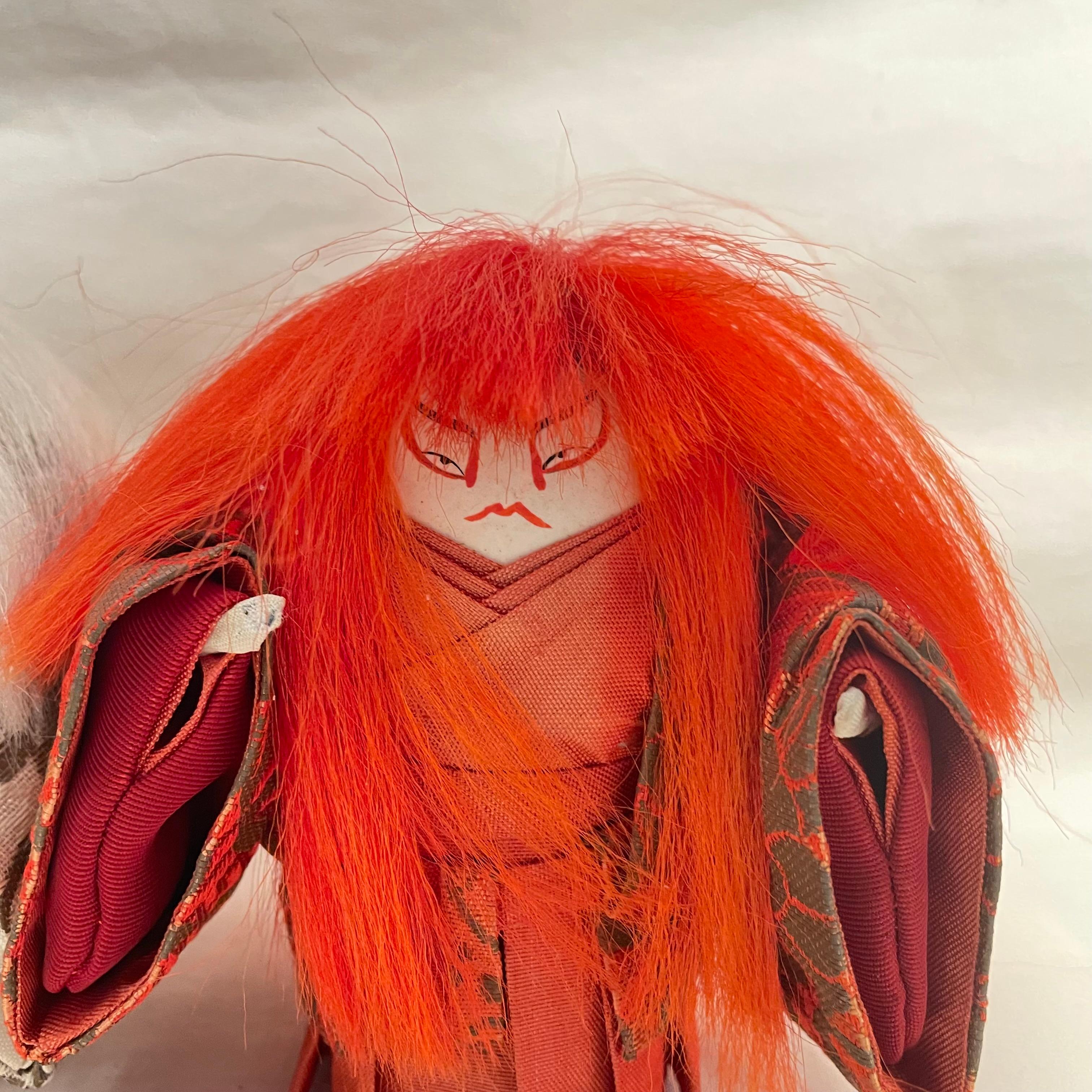 They are two Kabuki (Japanese theater) dolls made with woods and silk.
The woods are for body parts and silks are for kimono parts that they are wearing.
These dolls are from Renjishi Story.
They were made in Japan around 1990s in Showa