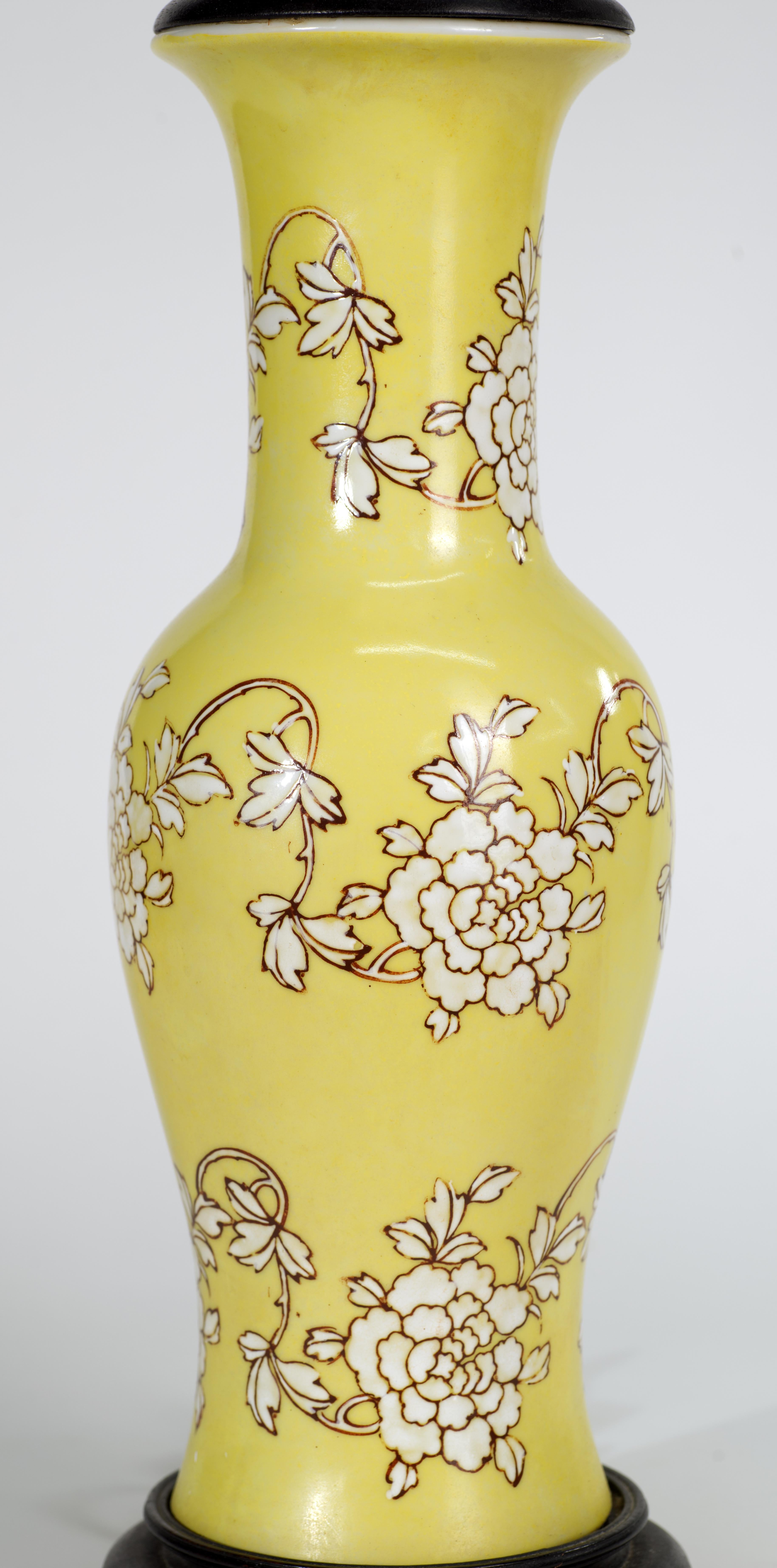 Cette élégante lampe de table en céramique de style oriental japonais présente un décor abstrait peint à la main de guirlandes de fleurs stylisées en glaçure blanche texturée avec des contours rouge-brun sur un fond jaune doux. La base et le sommet