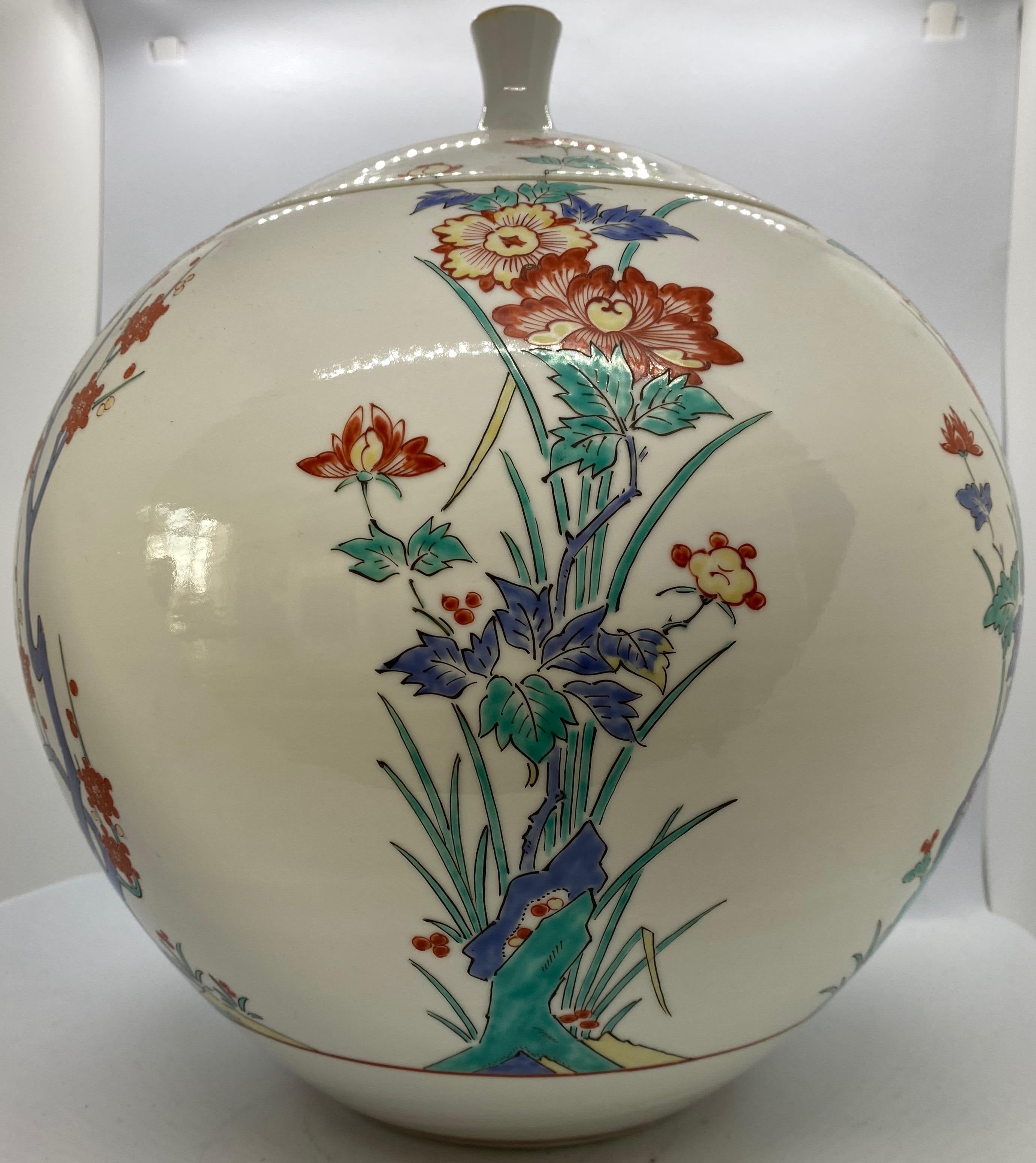 A fine and large Japanese vase in a fantastic shape. The painting goes over the vases side up on the lid so the lid has a specific place of wow to be placed.