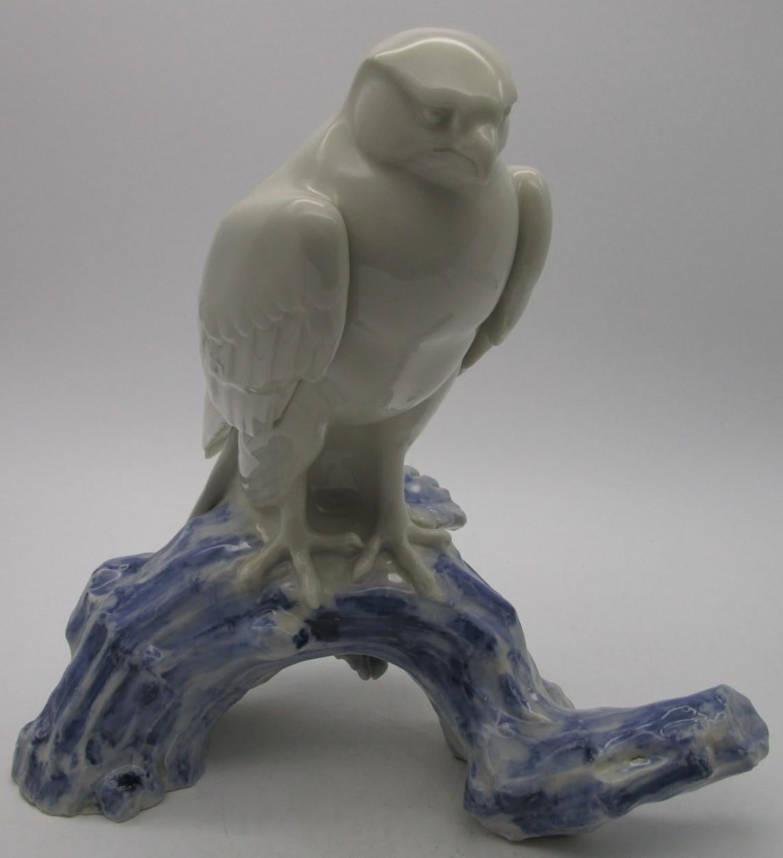 Japanese vintage signed porcelain sculpture from early years of Showa period (1926-1989,) dramatically showcasing an eagle resting on a branch. The branch is hand-painted in cobalt blue on white to create the details of the branch. The artist's