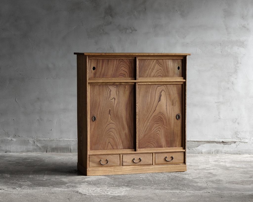 Este chadansu (armario para el té) de época se fabricó a principios del periodo Showa, en 1926.

El cuerpo principal es de madera de morera, mientras que las puertas correderas son de zelkova, con un diseño de vetas de madera especialmente