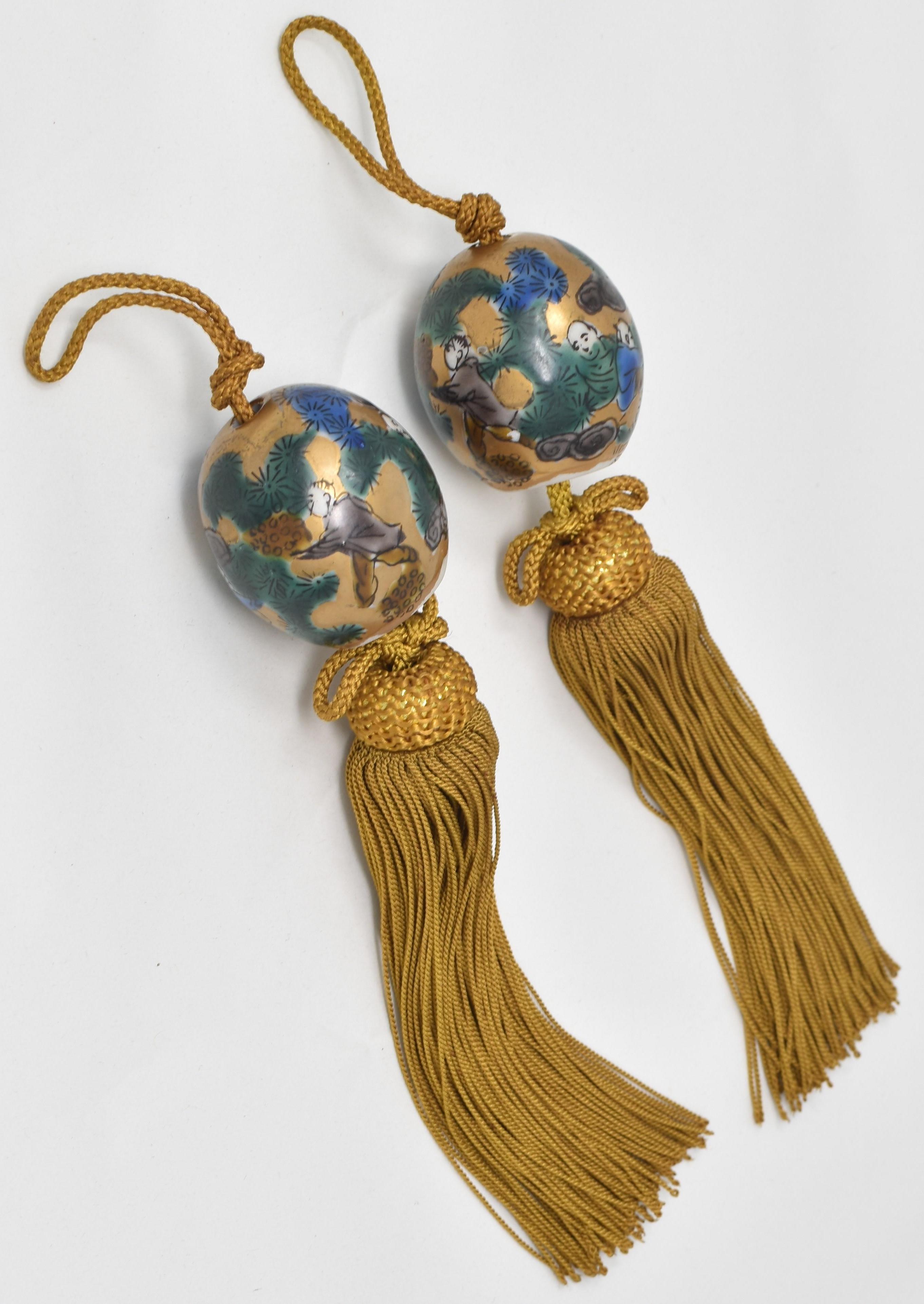 This attractive pair of vintage porcelain scroll weights (fuchin) is from the Kutani region of Japan.
Dating from the prewar Showa period of circa 1930, these egg-shaped scroll weights are gilded and hand-painted in the celebrated Mokubei style of