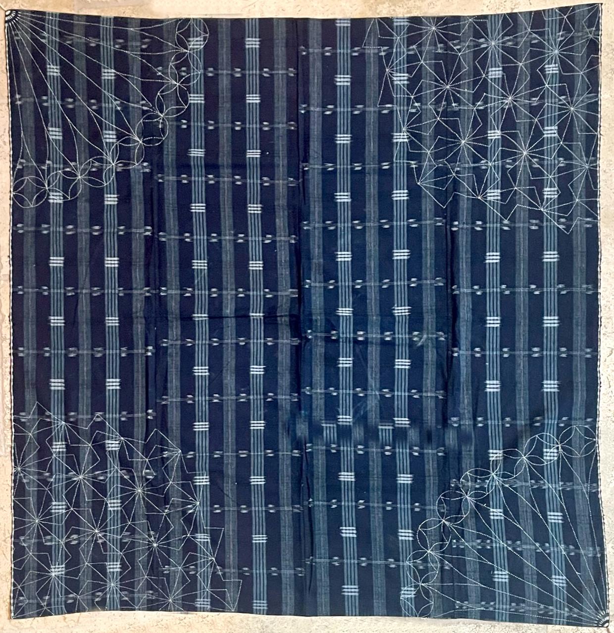 A Japanese hand-woven textile panel with indigo blue background with alternative white stripes intercepted with shorter horizontal ikat bands. Sewn together from four loom-woven narrower stripes, the large panel likely served as a Futonji (futon