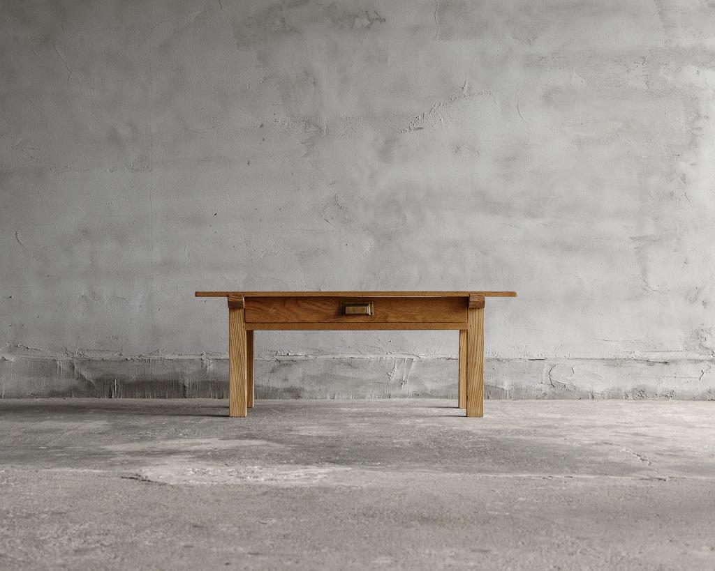 This vintage small low table was crafted in the Mid Showa Period (1926-).

Crafted from castor aralia wood, this petite writing desk boasts a simple and understated design with drawers included. Its compact size makes it perfect for use as a coffee