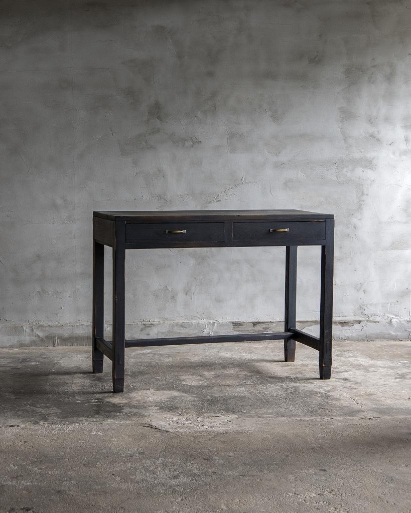 Este escritorio de época fue fabricado en el Periodo Showa Temprano '1926-'.

Fabricado íntegramente con madera maciza de kihada (alcornoque japonés de Amur).

Con un elegante acabado en negro y un diseño minimalista, esta pieza aporta una presencia