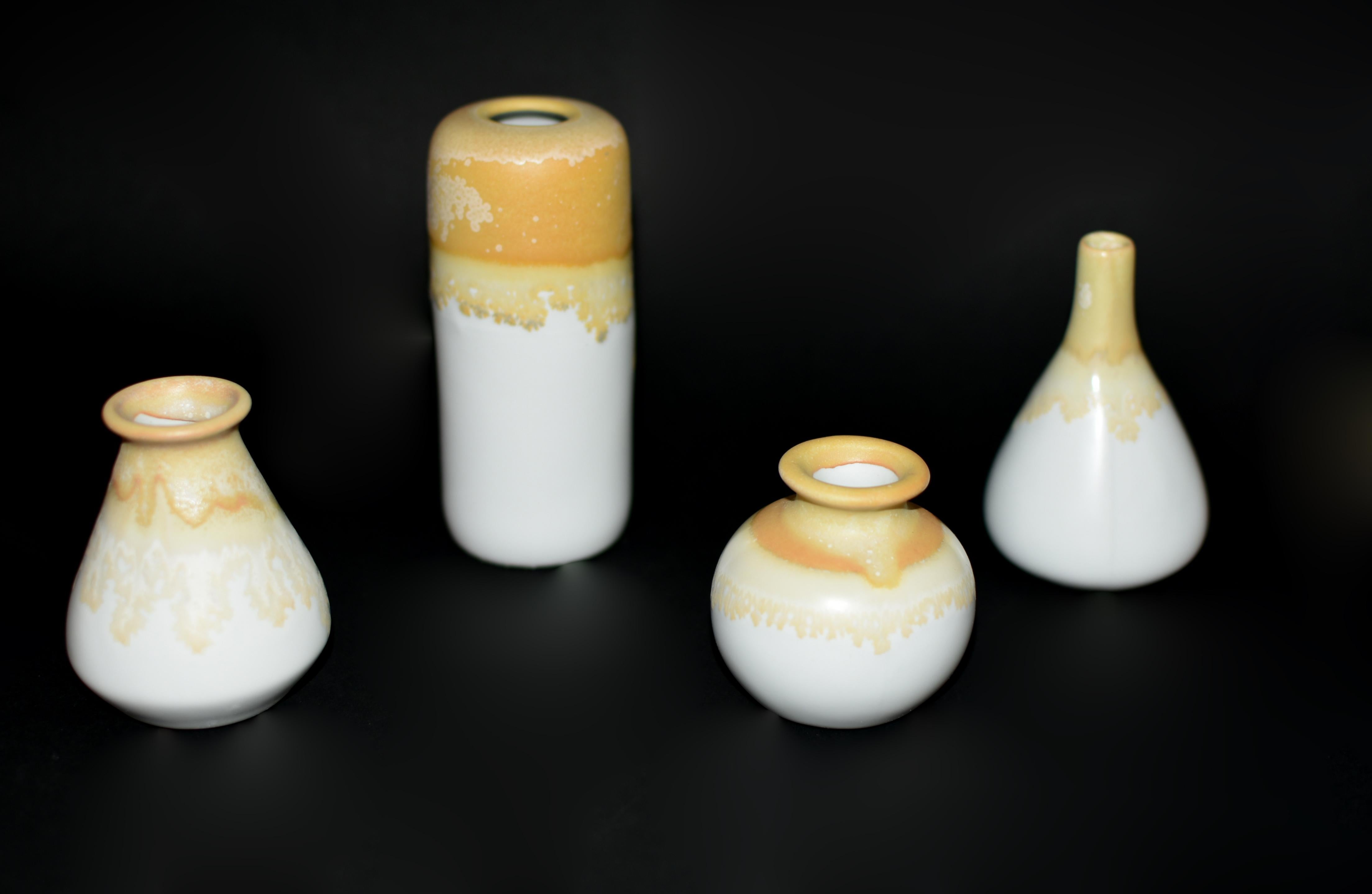 Un bellissimo set di quattro mini vasi in ceramica, ognuno dei quali è stato sapientemente realizzato e dipinto a mano e rifinito con uno splendido smalto. I delicati disegni presentano un'armoniosa miscela di crema e oro, che evoca l'essenza delle
