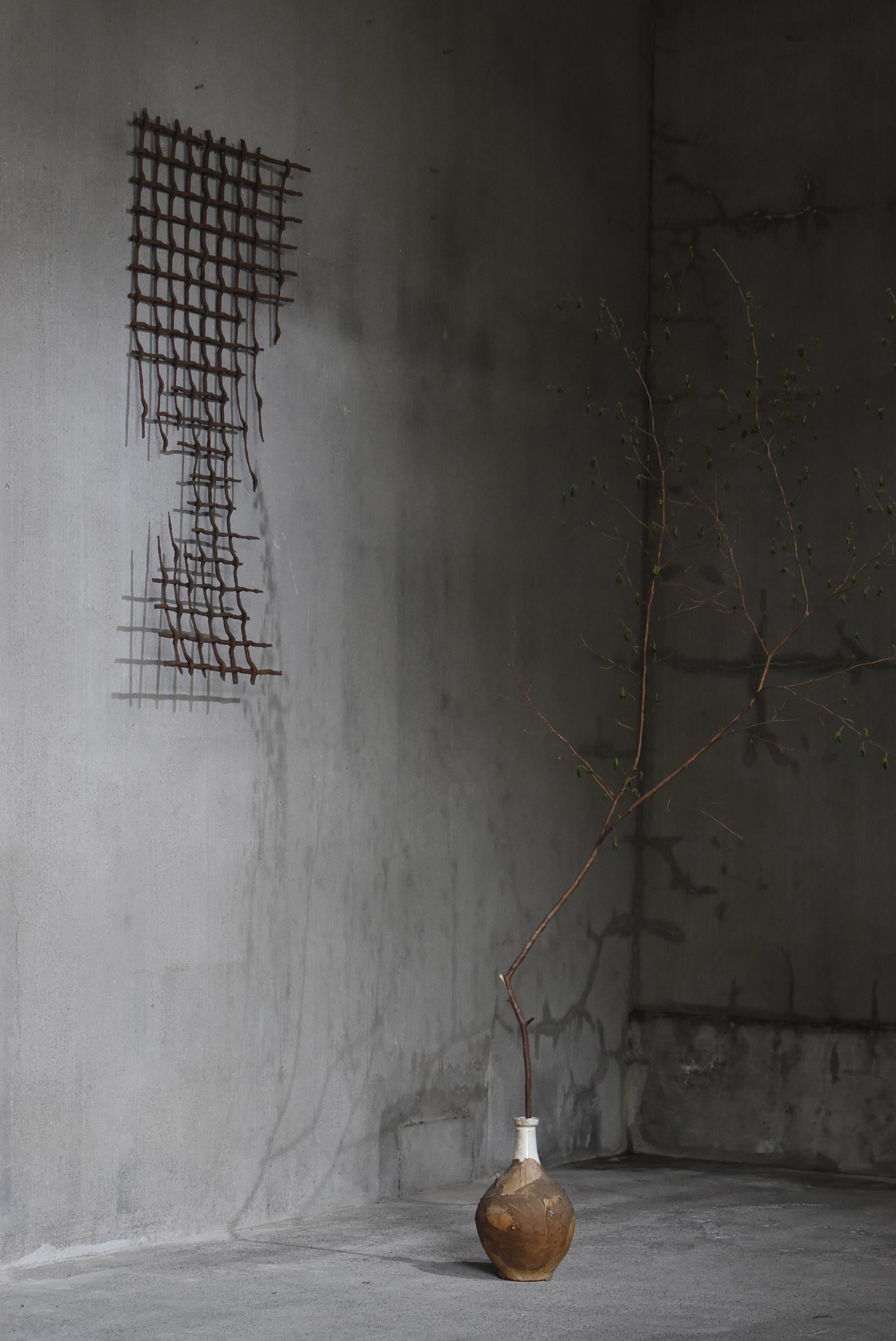 Se trata de una malla de hierro oxidado fabricada en Japón.
Es un artículo del periodo Showa (1940-1960).

La exposición al tiempo, a la intemperie y a la lluvia ha deteriorado bellamente el hierro, dándole una textura única.
Esta expresión creada