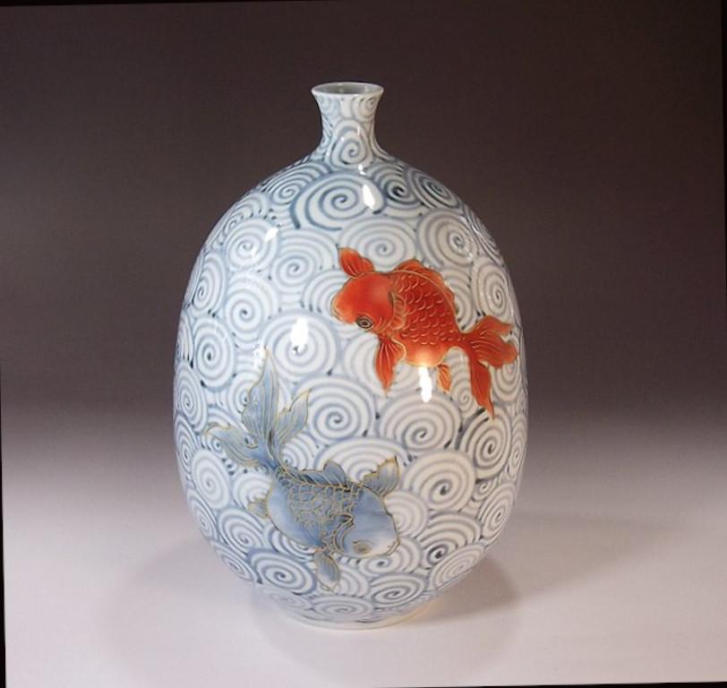 Unique Japanese contemporry decorative porcelain vase, hand painted in red and beautiful shades of blue on an elegantly shaped ovoid porcelain body, a signed piece by widely acclaimed Japanese master porcelain artist in the Imari-Arita tradition. In