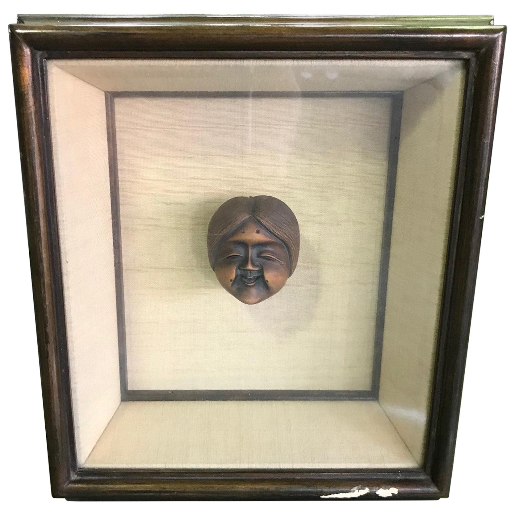 A wonderfully detailed and displayed miniature well-carved wood Japanese netsuke of a old smiling woman. These decorative pieces often hung from drawstrings of small Inro pouches, which Japanese men customarily wore suspended and sometimes hidden on