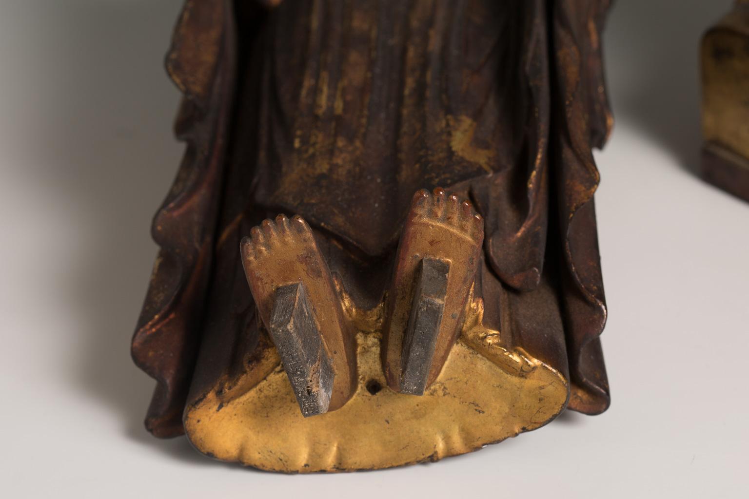 The Amitabha (Amida in Japanese) Buddha is shown standing with his hands forming the Amida raigo-in mudra. The face has a serene expression, with closed eyes under delicately arched brows and a severe face. The hair is arranged in rows of coils that