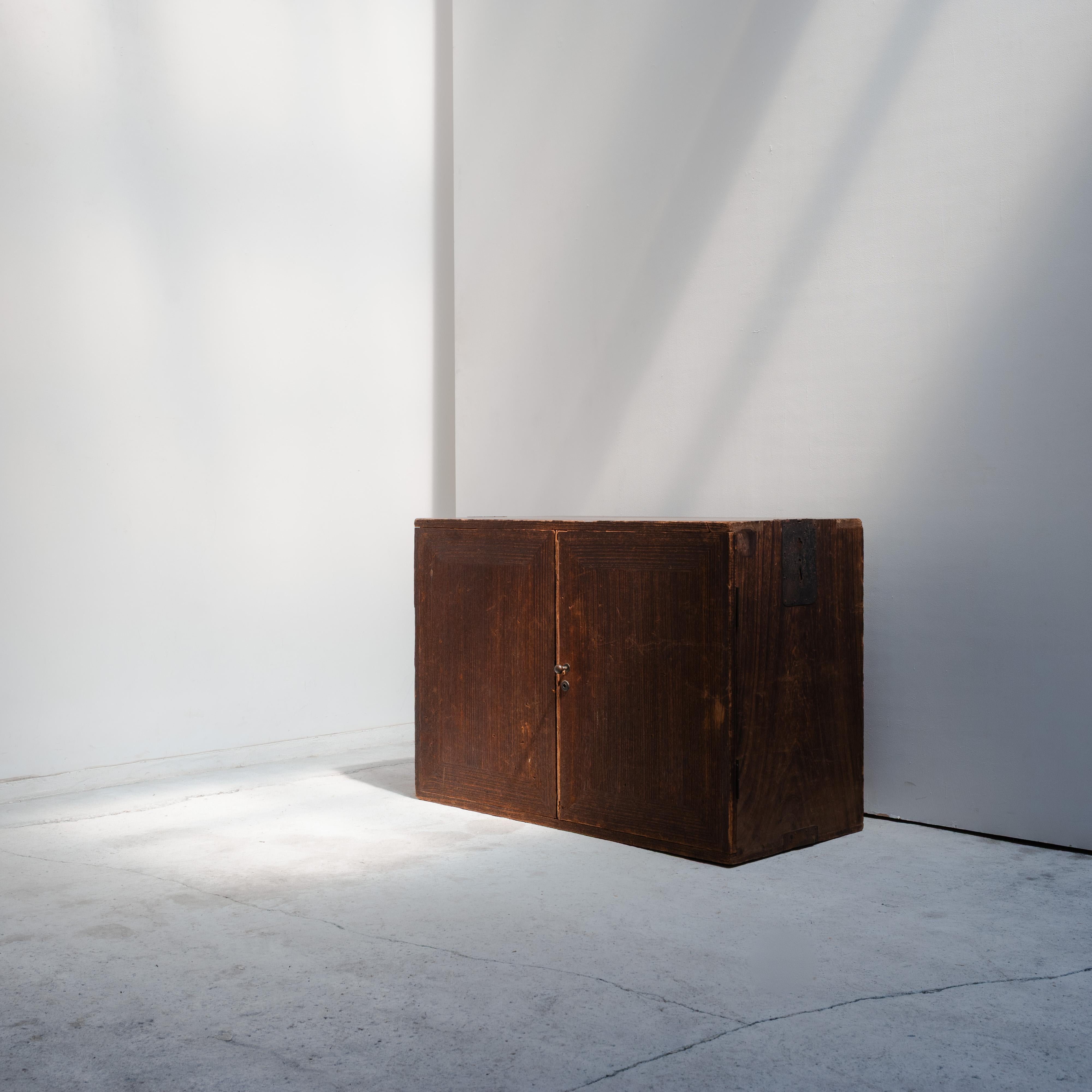 A characterful Japanese archival cabinet from the early 20th century, crafted from wood and defined by its deeply grooved doors and minimalist construction. The front panels open to reveal four drawers, each with delicately carved semicircular