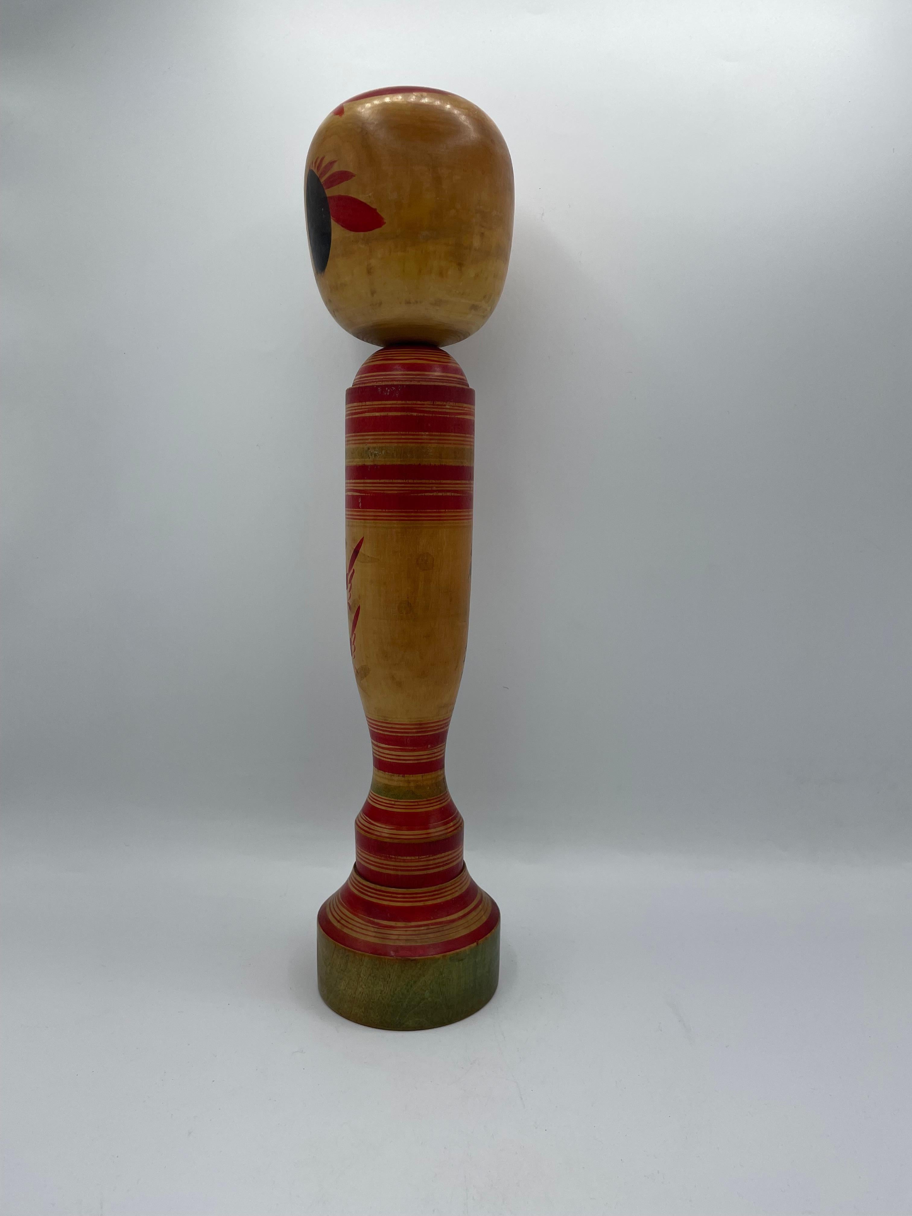 This is a wooden doll which is called Kokeshi in Japanese.
This kokeshi was made in Japan around 1960s by kokeshi artist Kenjiro HIRAGA.
He was born in 17th November 1918. His signature is written on the back of this kokeshi doll.
This kokeshi was