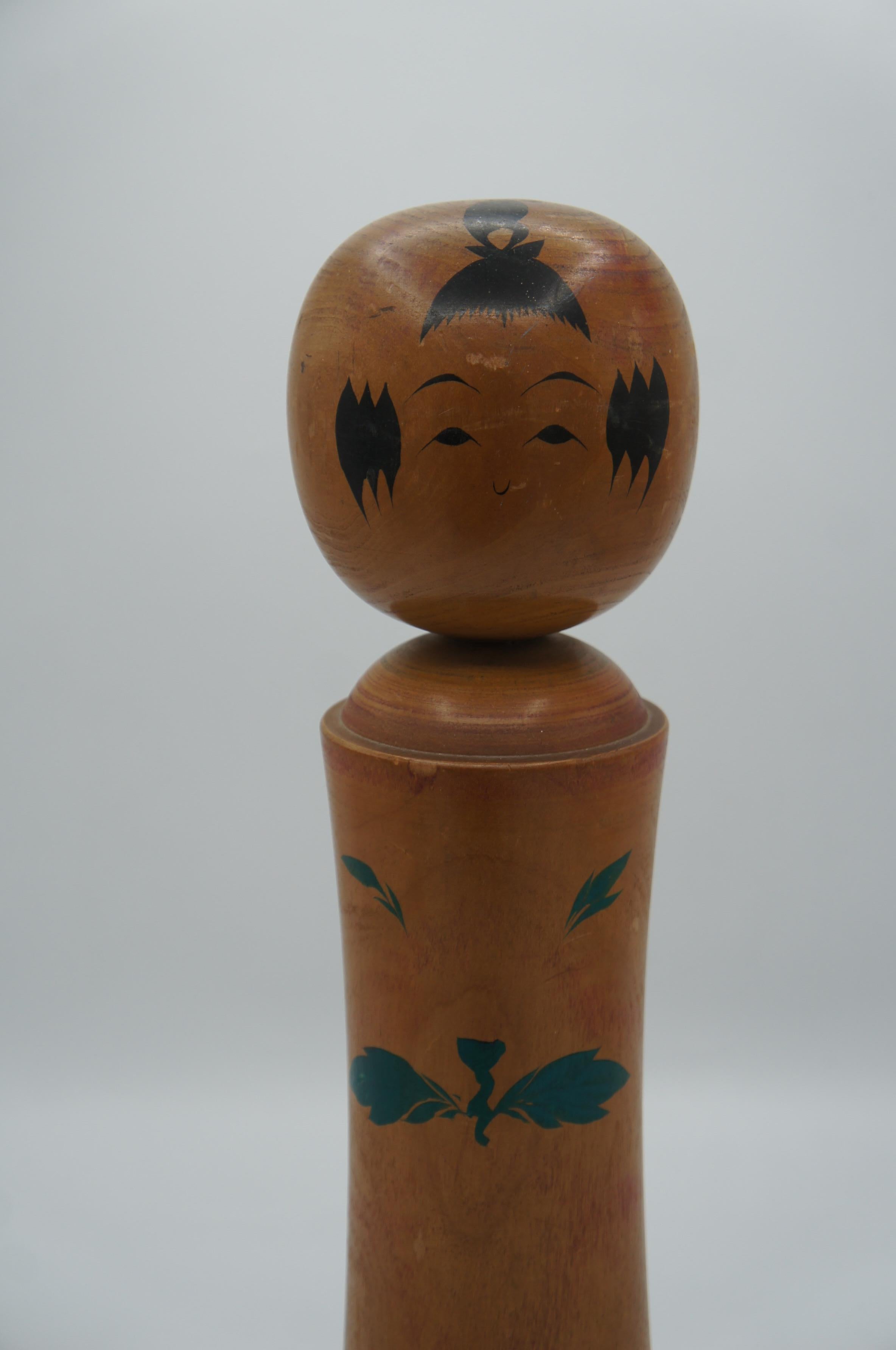This is a wooden doll which was made in Japan around 1950 in Showa era. 
This kind of dolls are called Kokeshi in Japanese.
This kokeshi's style is Naruko from Miyagi prefecture.
This kokeshi was made by a kokeshi artist Takumi KUMAGAYA. You can