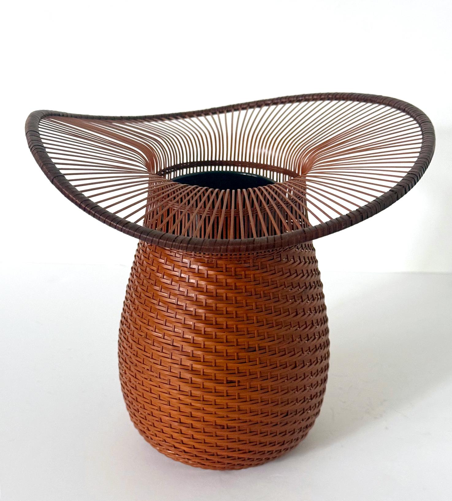 Intitolato Toujingasa (Cappello cinese), questo delicato cesto ikebana intrecciato a mano è stato realizzato dall'artista giapponese di bambù Jin Morigami (1955-) nel 2005 circa. Realizzato in bambù e rattan e rivestito di lacca, l'artista combina