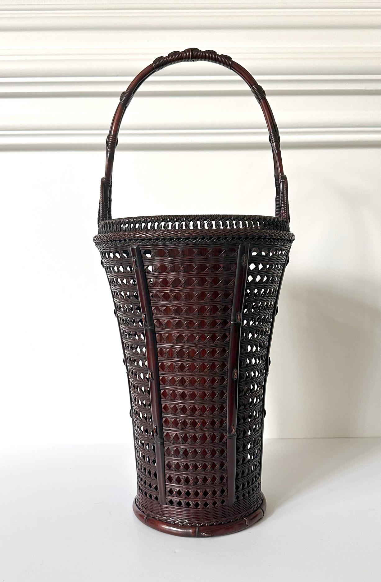 A tall woven bamboo ikebana hanakago (flower basket) circa first half of the 20th century (Taisho or Showa era) by Japanese bamboo master Maeda Chikubosai I (1872-1950). Hand-woven with bamboo and rattan and equipped with a copper lined bamboo inner