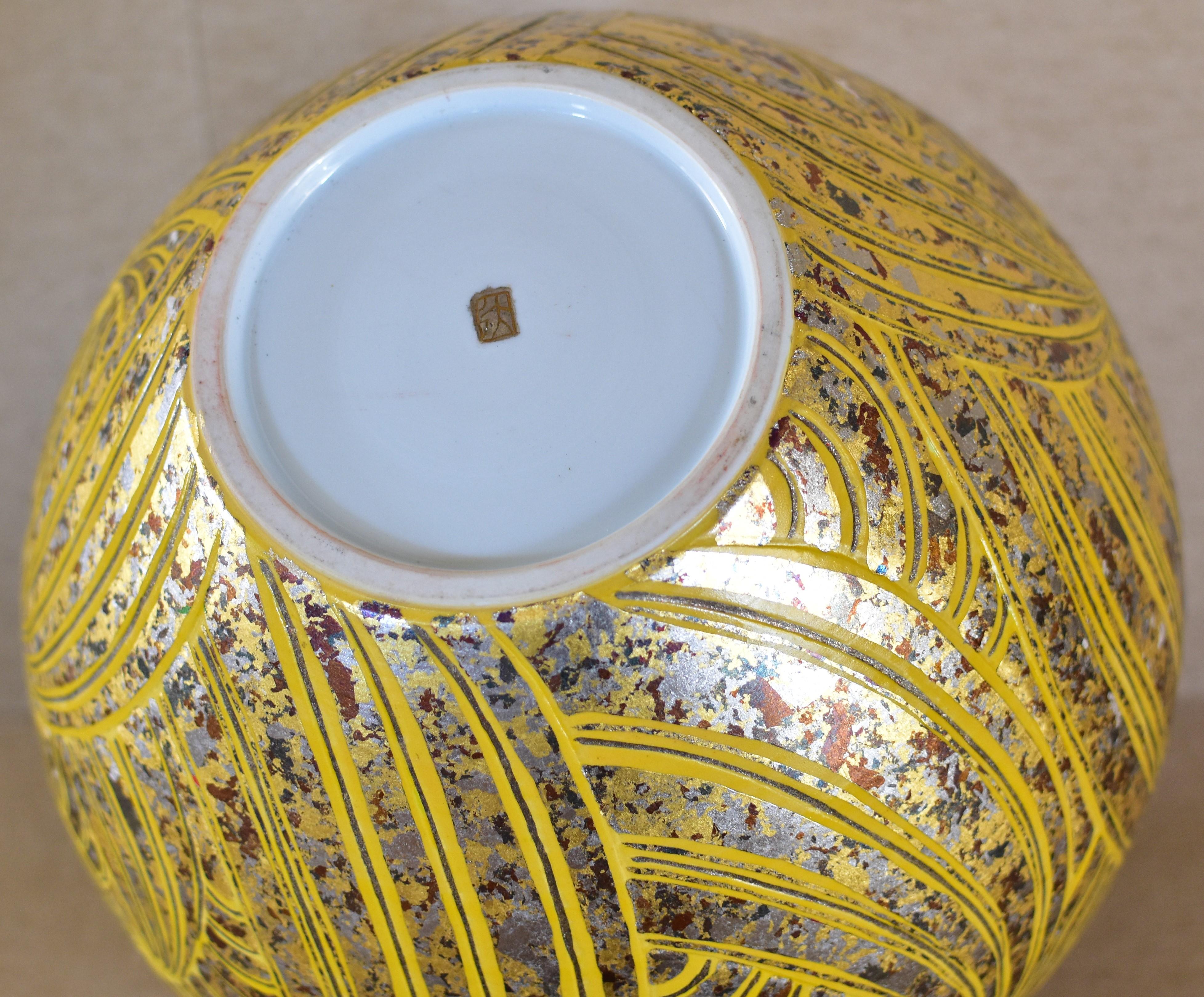 Mesmerizing contemporary porcelain vase in vivid yellow adorned with etchings in a complicated pattern features silver foil in platinum, gold and a beautiful combination of multiple colors, meticulously positioned using lacquer as an adhesive and