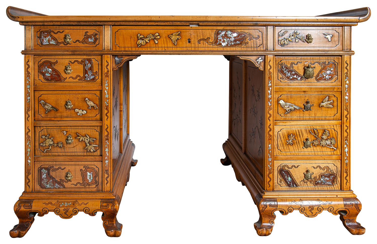 A wonderfully stylized Japanned partners pedestal desk, having carved, inlaid and engraved classical decoration, an inset leather top, eleven drawers to one side, each with brass turtle handles, the reverse with engraved mother of Pearl inlaid