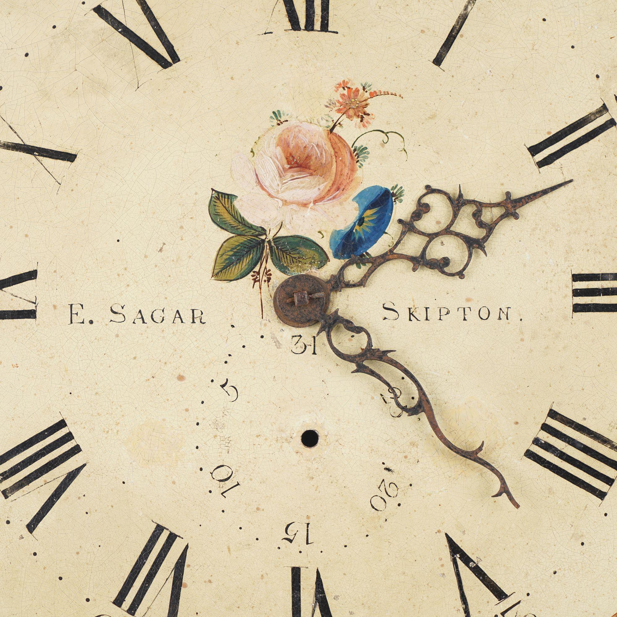Cadran de l'horloge en acier japanné avec des roses anglaises dans les écoinçons et au centre avec un cadran à chiffres arabes. Le cadran de l'horloge conserve ses aiguilles en acier d'origine. Edmund Sagar a travaillé dans plusieurs villes