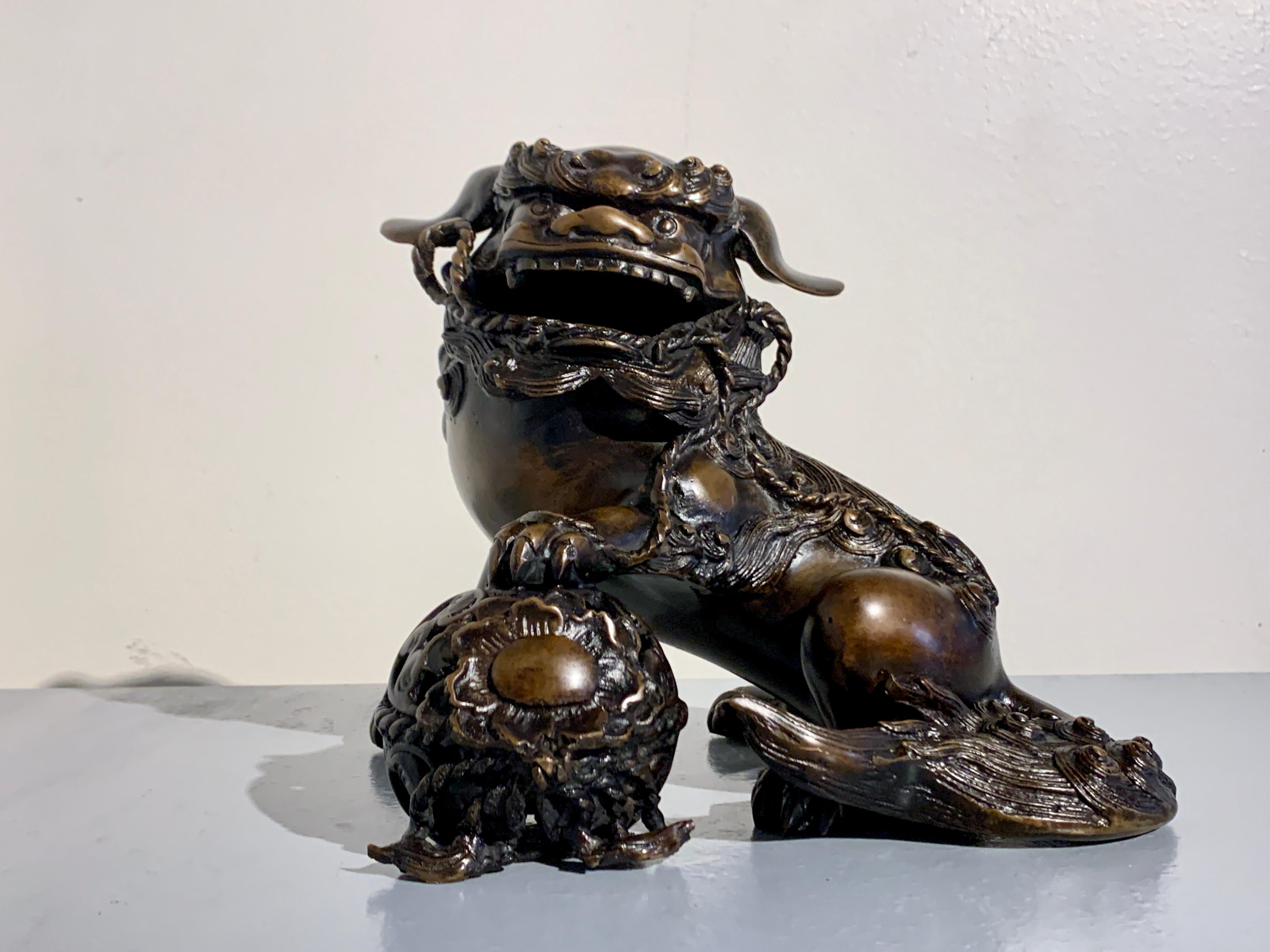 A heavy and powerfully cast Japanese bronze model of a shishi or foo lion by Hideyama / Shuzan, Meiji Period, circa 1900, Japan.

The dramatic lion, known as a shishi in Japan, is cast as both a powerful and playful being. He is portrayed seated