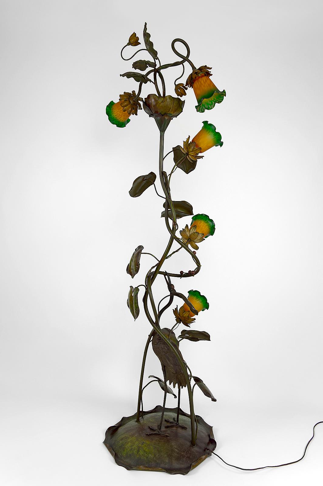 An exceptional piece!

Superb sculpture floor lamp in patinated and painted bronze and brass, depicting a Japanese crane (tsuru) / heron / wading bird picking red berries in the middle of lush nature (flowers, water lily leaves).

5 lights with