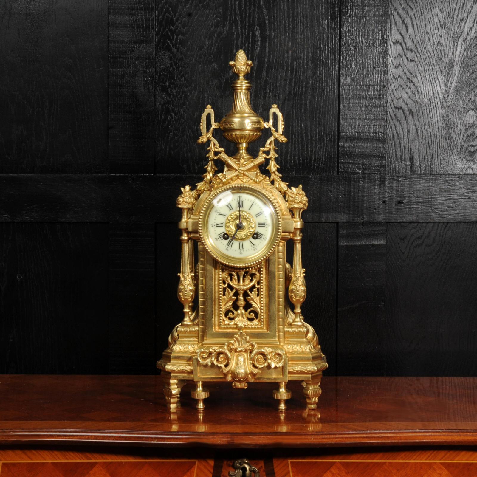A beautiful original gilt bronze antique French clock in the neoclassical style of Louis XVI by the renown maker Japy Frères. Architecturally designed and profusely decorated with acanthus scrolls and foliage. Above the dial is a motif of flaming