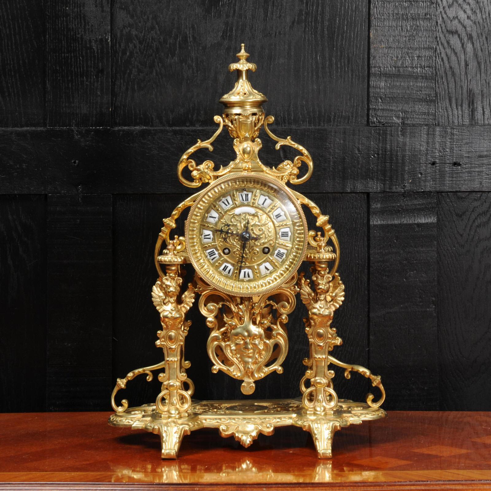 A very decorative gilt bronze portico clock by the famous maker Japy Frères, dating from circa 1890. It is Baroque in style featuring four pillars of winged mythical creatures holding the movement aloft. The gilt bronze pendulum swings visibly