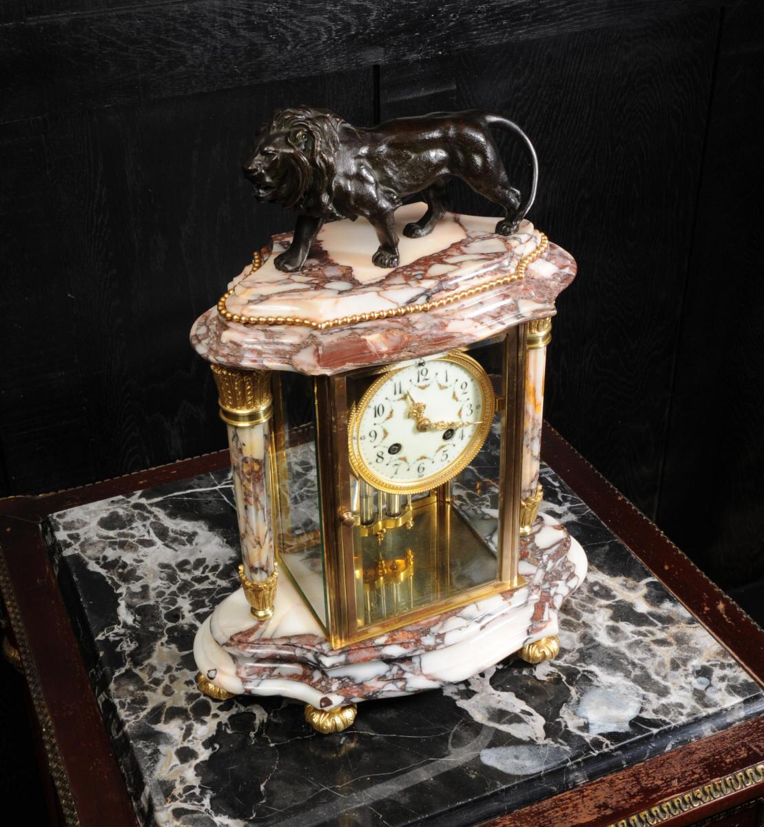 A beautiful antique French specimen marble library four glass or crystal regulator clock by the renown maker Japy Frères, circa 1880. It is classical in style with two reeded acanthus troche columns and a well modeled bronze lion standing proudly to