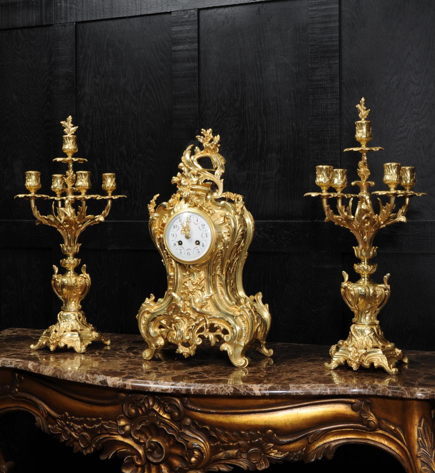 A large and stunning original antique French gilt bronze clock set by Japy Freres, circa 1890. The clock is of waisted shape, formed of 'C' scrolls and acanthus. Below the dial is a panel of musical trophies and a pair of birds, symbolic of love. To