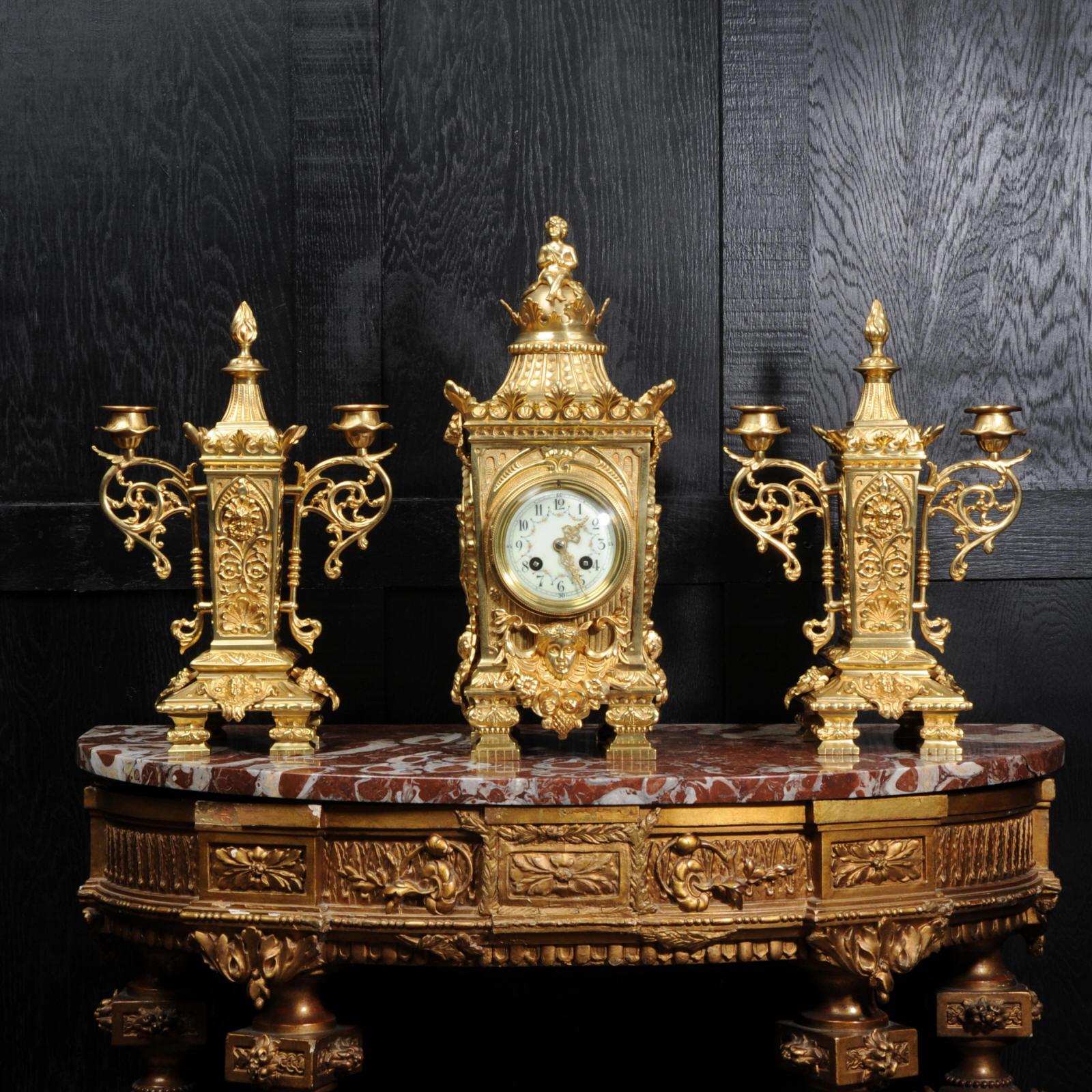 A beautiful, classically designed antique French gilt bronze clock set by Japy Frères. It features oval panels to the sides showing Fortuna, the goddess of luck, an emperor to the front and lions masks. To the top of the clock is a cherub on a globe