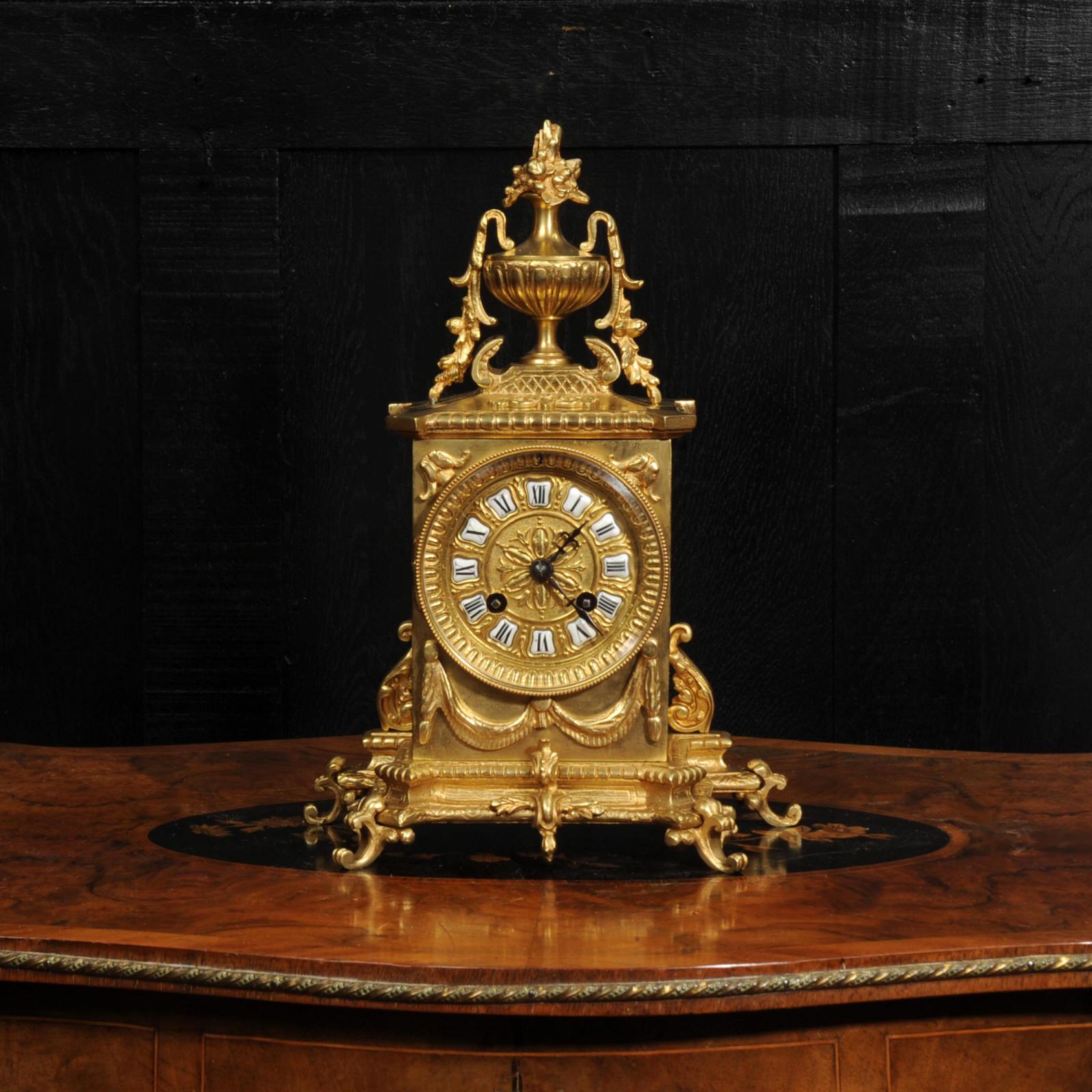 A stunning original antique French gilt bronze clock by the renown maker Japy Frères. Of architectural form, the case finely cast in gilt-bronze with neoclassical ornament, surmounted by a twin-handled urn issuing a bouquet of flowers. To the sides